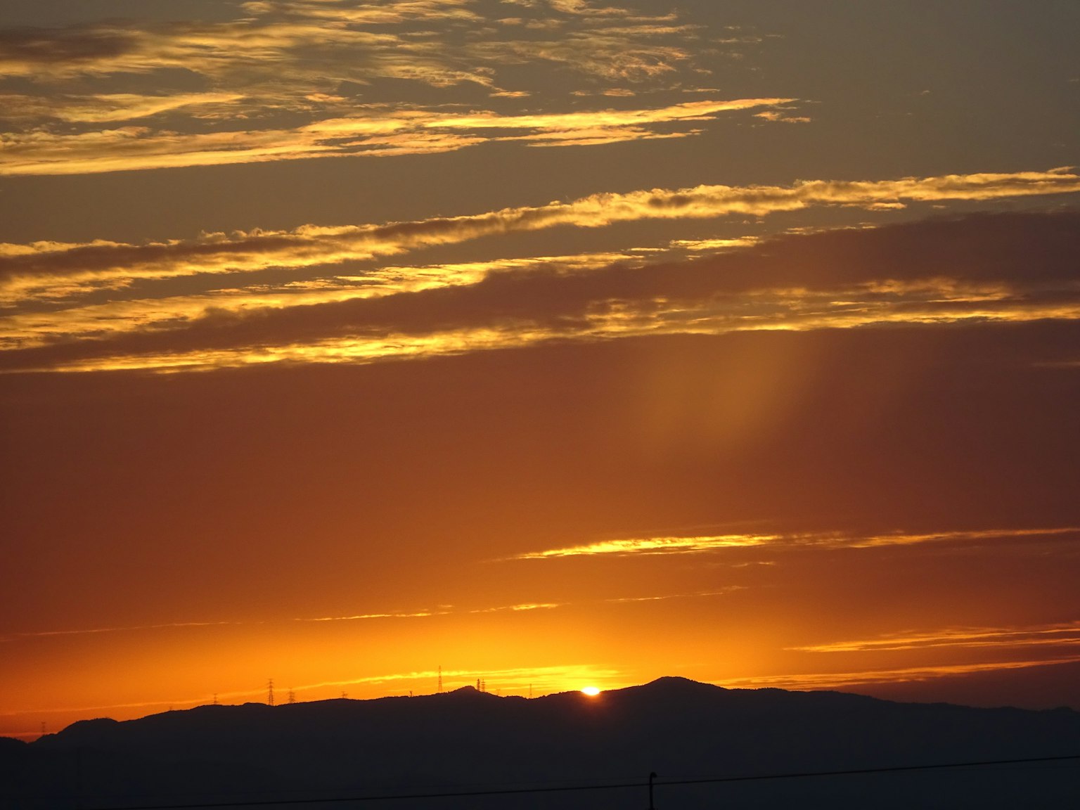 Beautiful orange and yellow sunset sinking behind the mountains