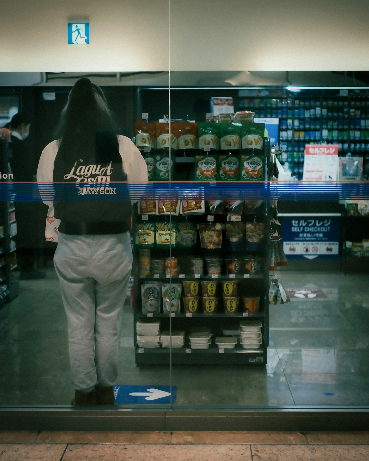 Person, die vor einem Produktdisplay hinter Glas steht