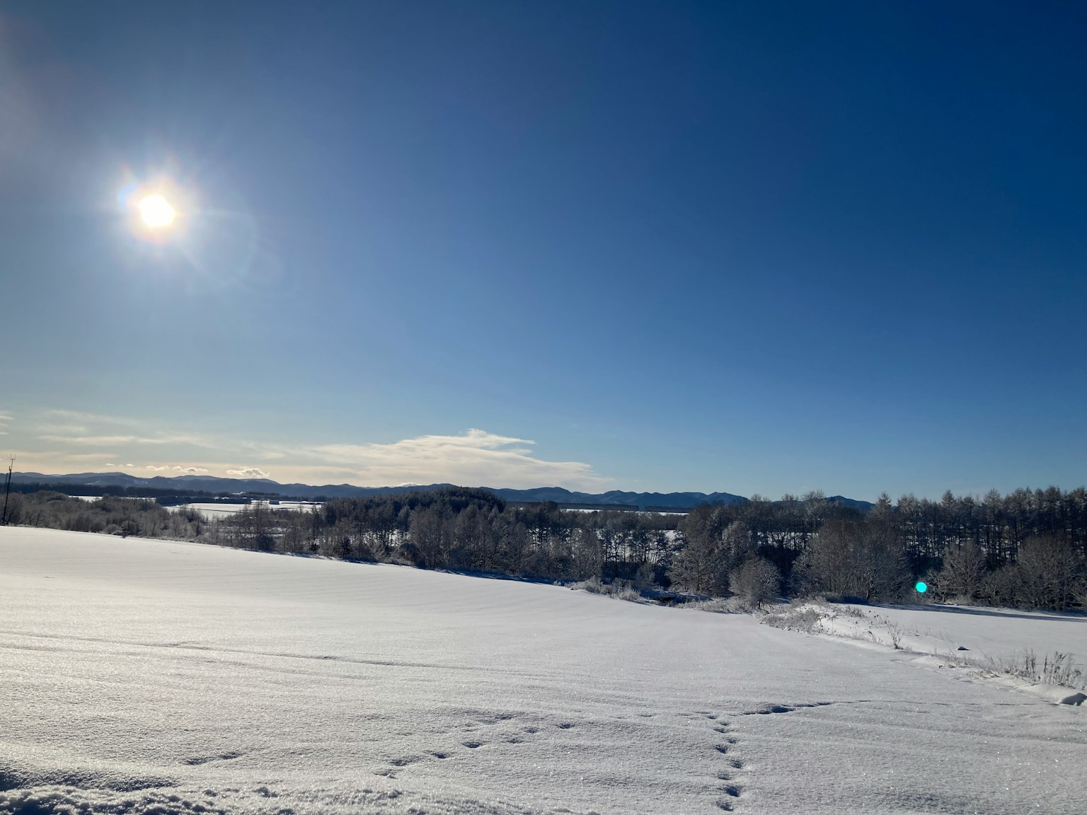 Paisaje nevado bajo un cielo azul brillante con sol resplandeciente