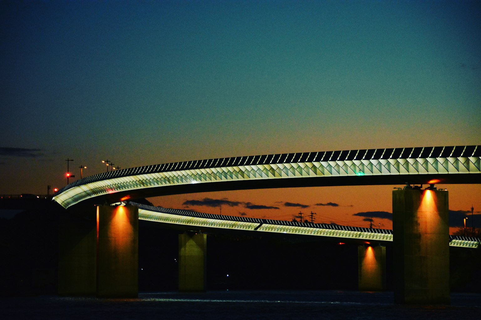 Struktur jembatan modern yang diterangi di bawah langit senja