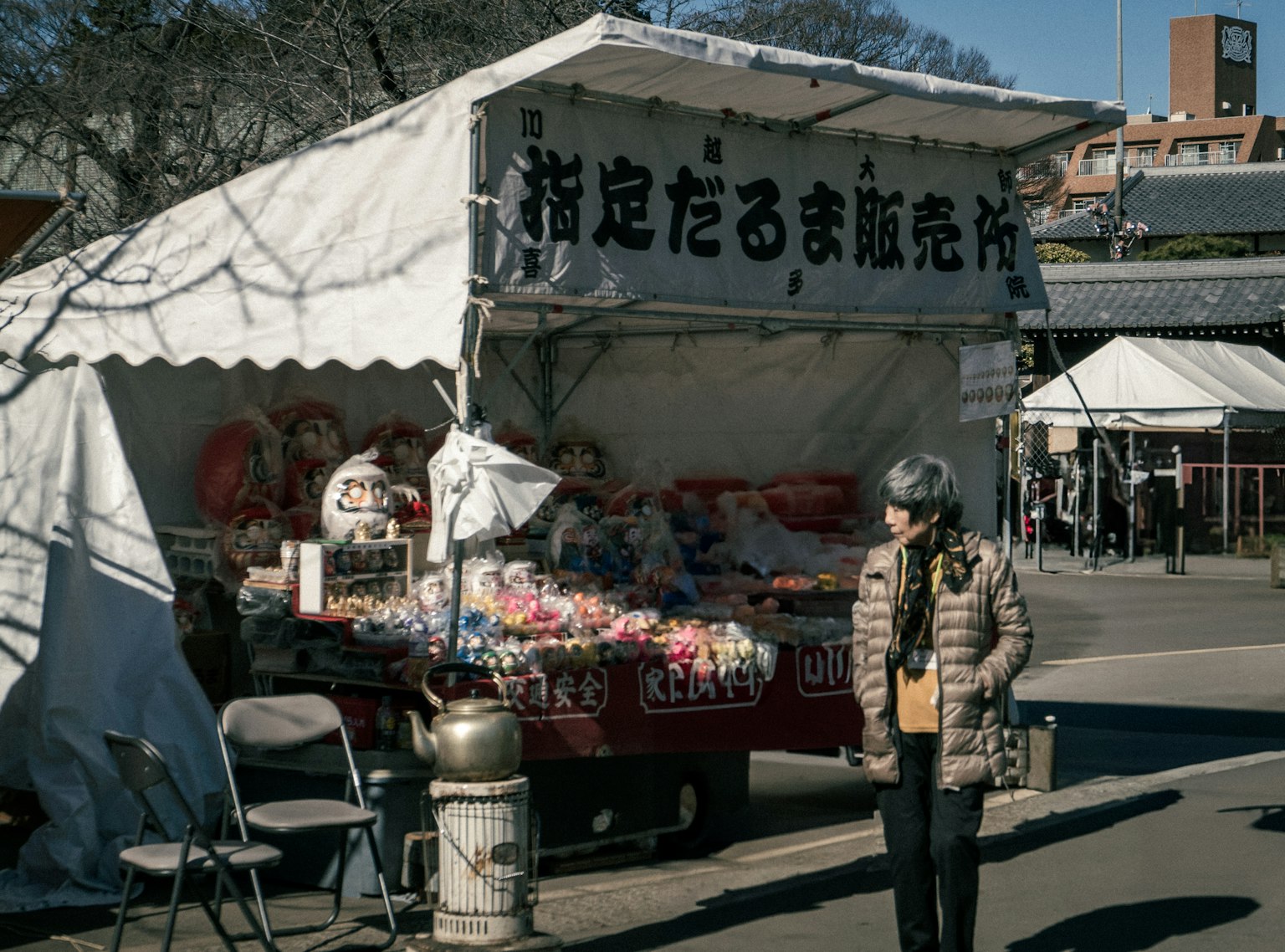 一个人站在一个展示多彩产品的摊位前