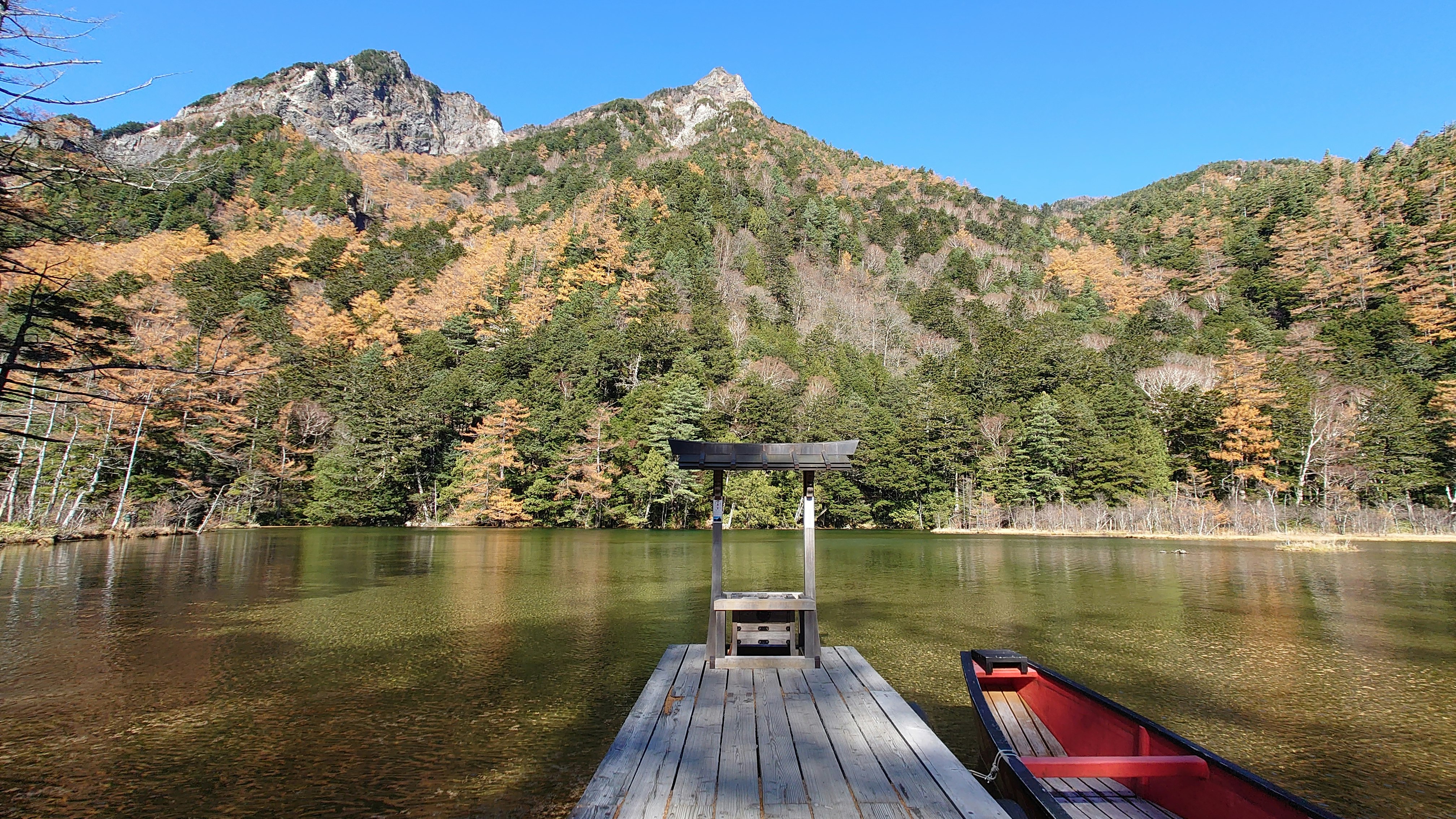 湖邊碼頭與紅色獨木舟的山景