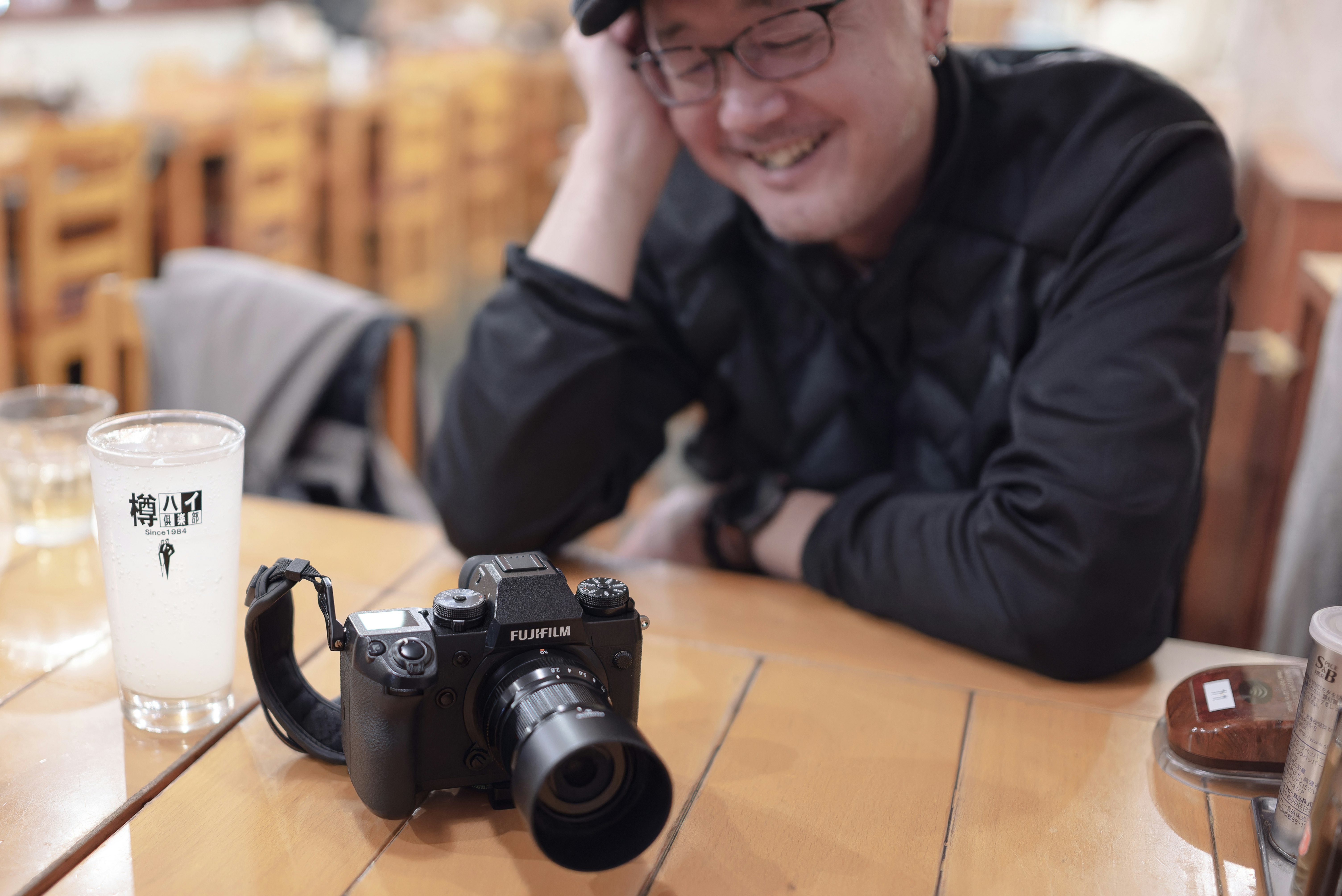 カフェのテーブルで笑顔の男性とカメラ
