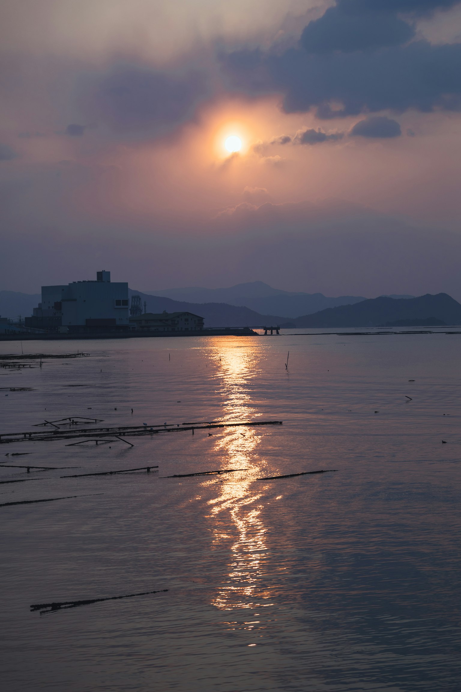 寧靜的海景夕陽映射在水面上建築和山脈在背景中
