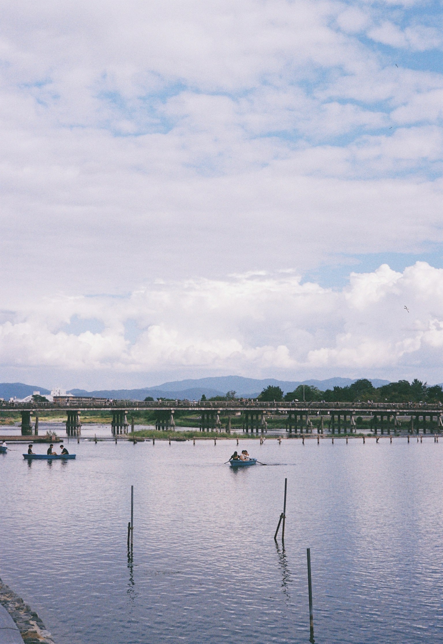 Ruhige Landschaft mit Booten auf dem Wasser und fernen Bergen im Hintergrund