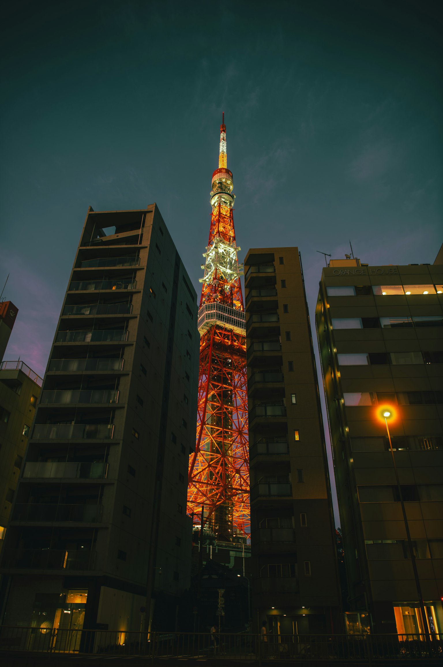 Torre di Tokyo illuminata di notte tra gli edifici