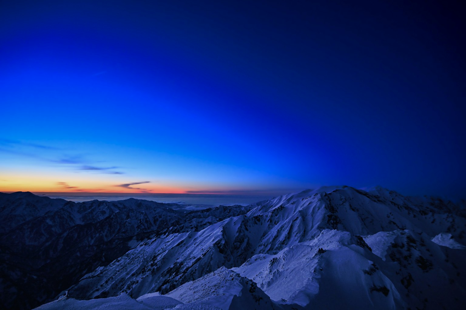 Puncak gunung bersalju di bawah langit biru gradasi