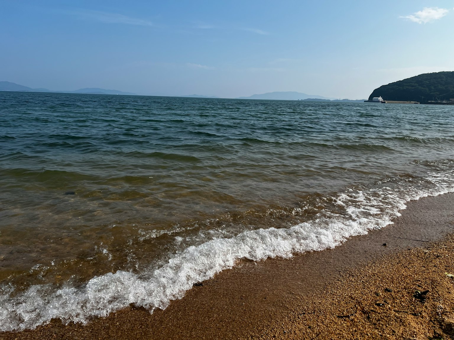 穏やかな海と砂浜の風景 青空と波の音が感じられる