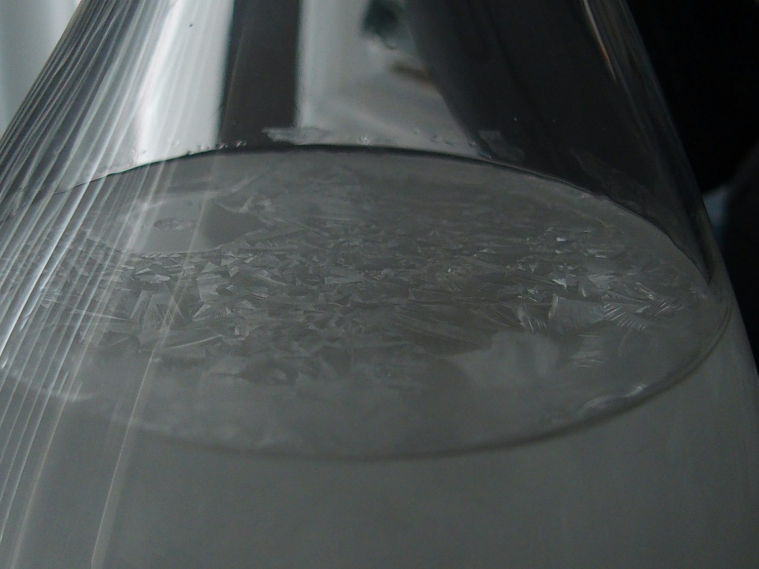 Primo piano di un flacone trasparente riempito d'acqua