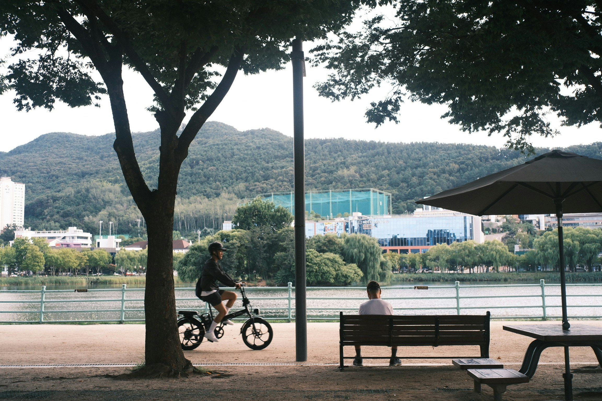 川沿いのベンチと自転車、山並みの風景