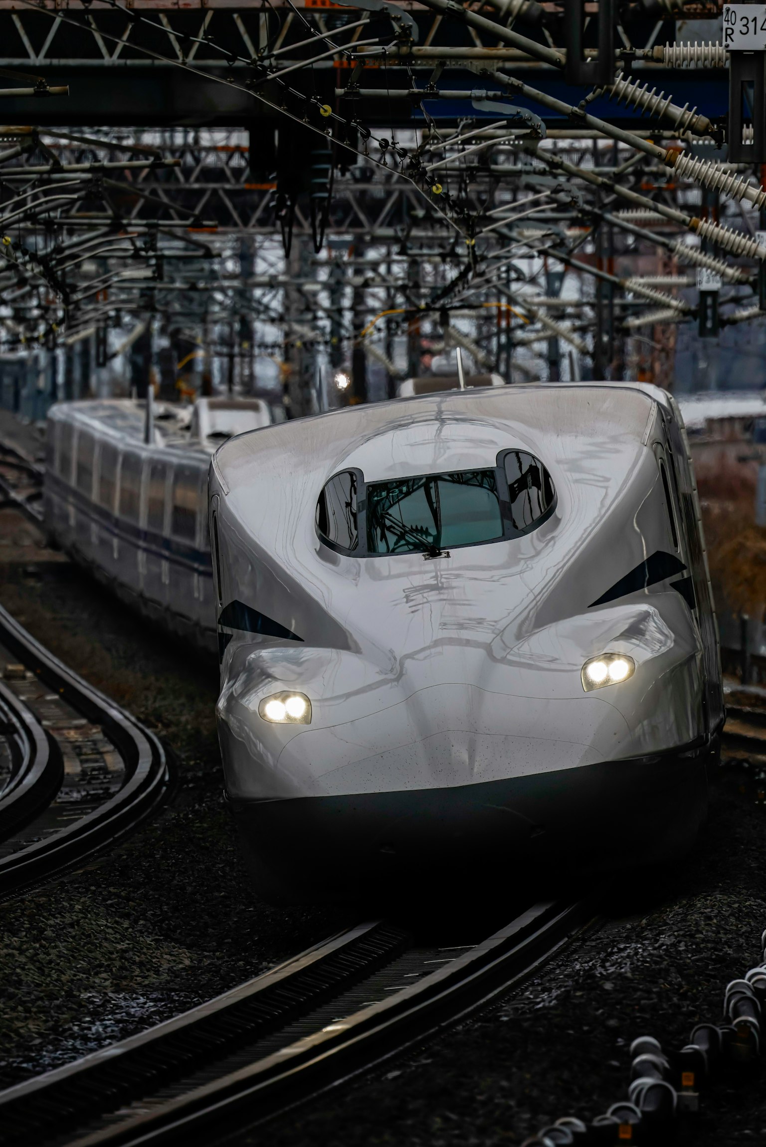 新幹線列車轉彎，具有現代設計和明亮的前燈