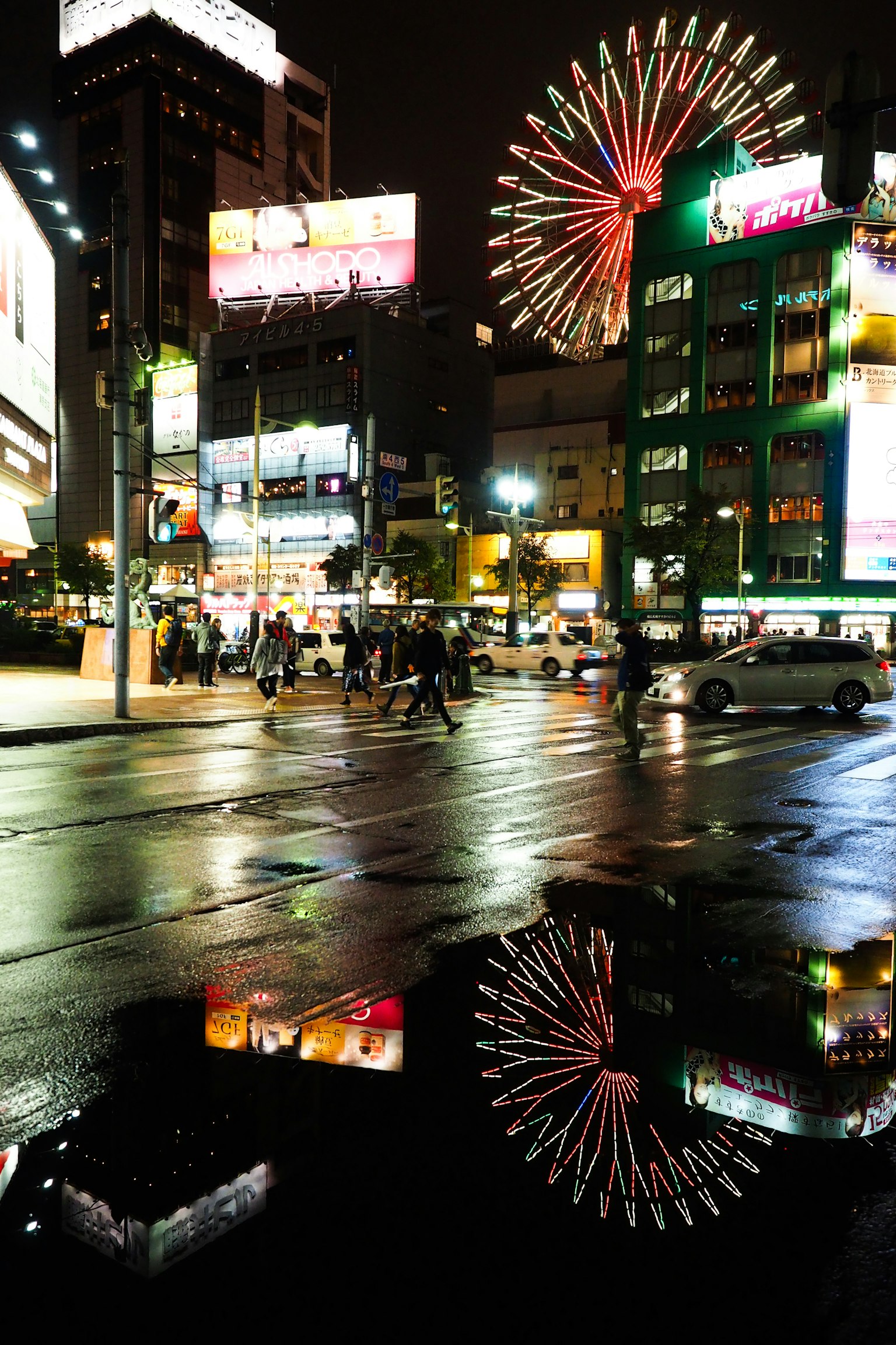 Night cityscape with reflections of a Ferris wheel and neon signs