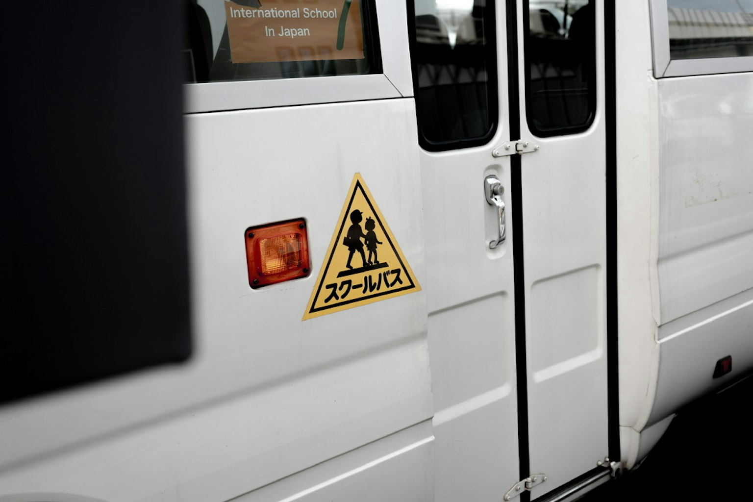 Segnale di avvertimento per scuolabus sul lato di un autobus bianco