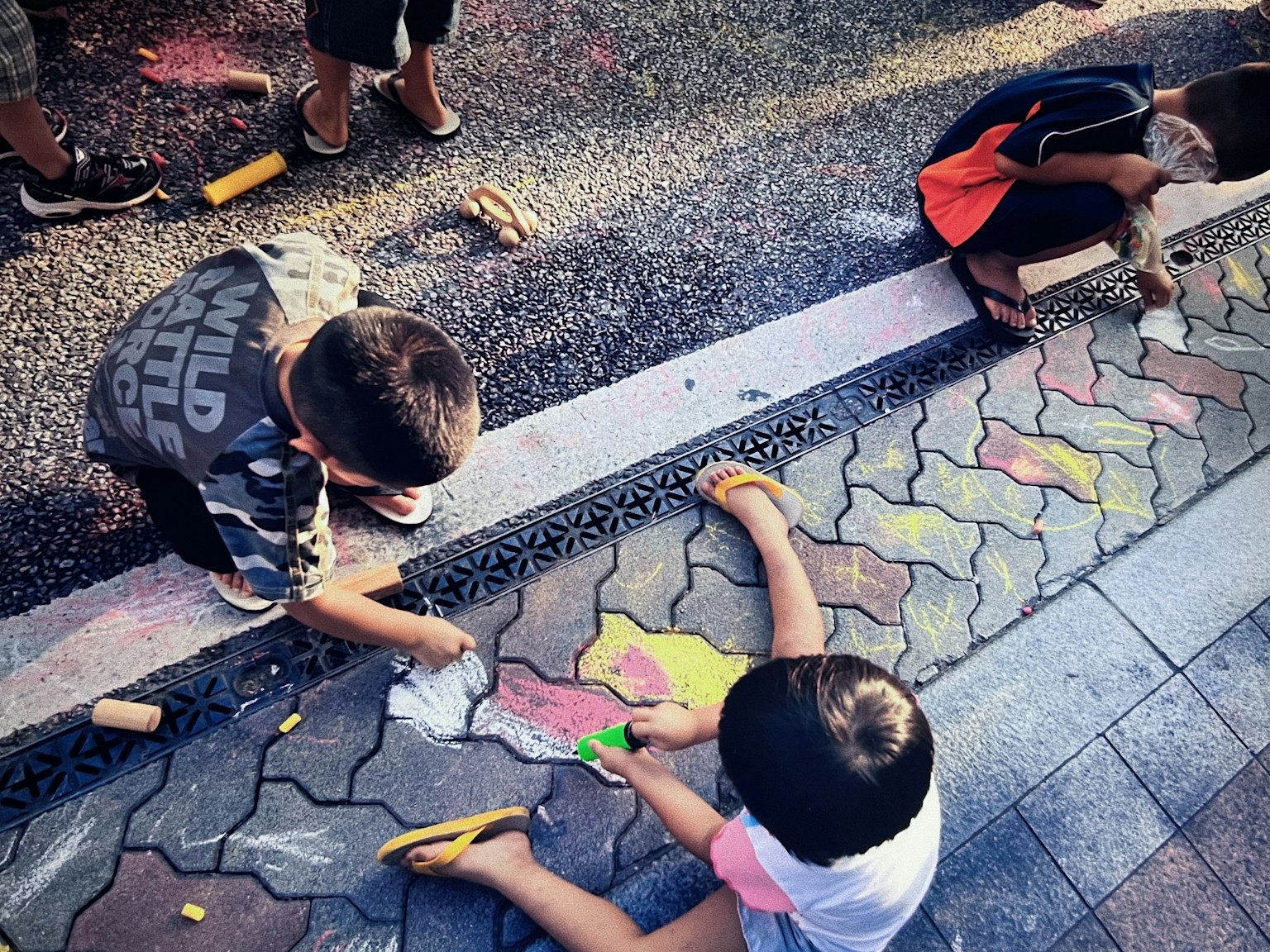 孩子們在路面上用彩色粉筆畫畫