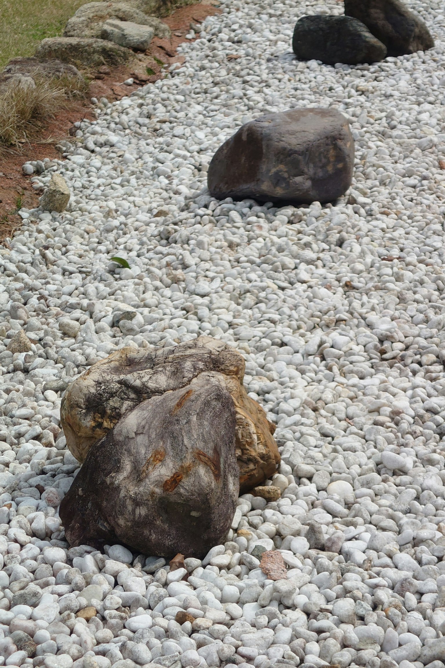 Grandes rocas colocadas sobre un lecho de guijarros blancos en un paisaje