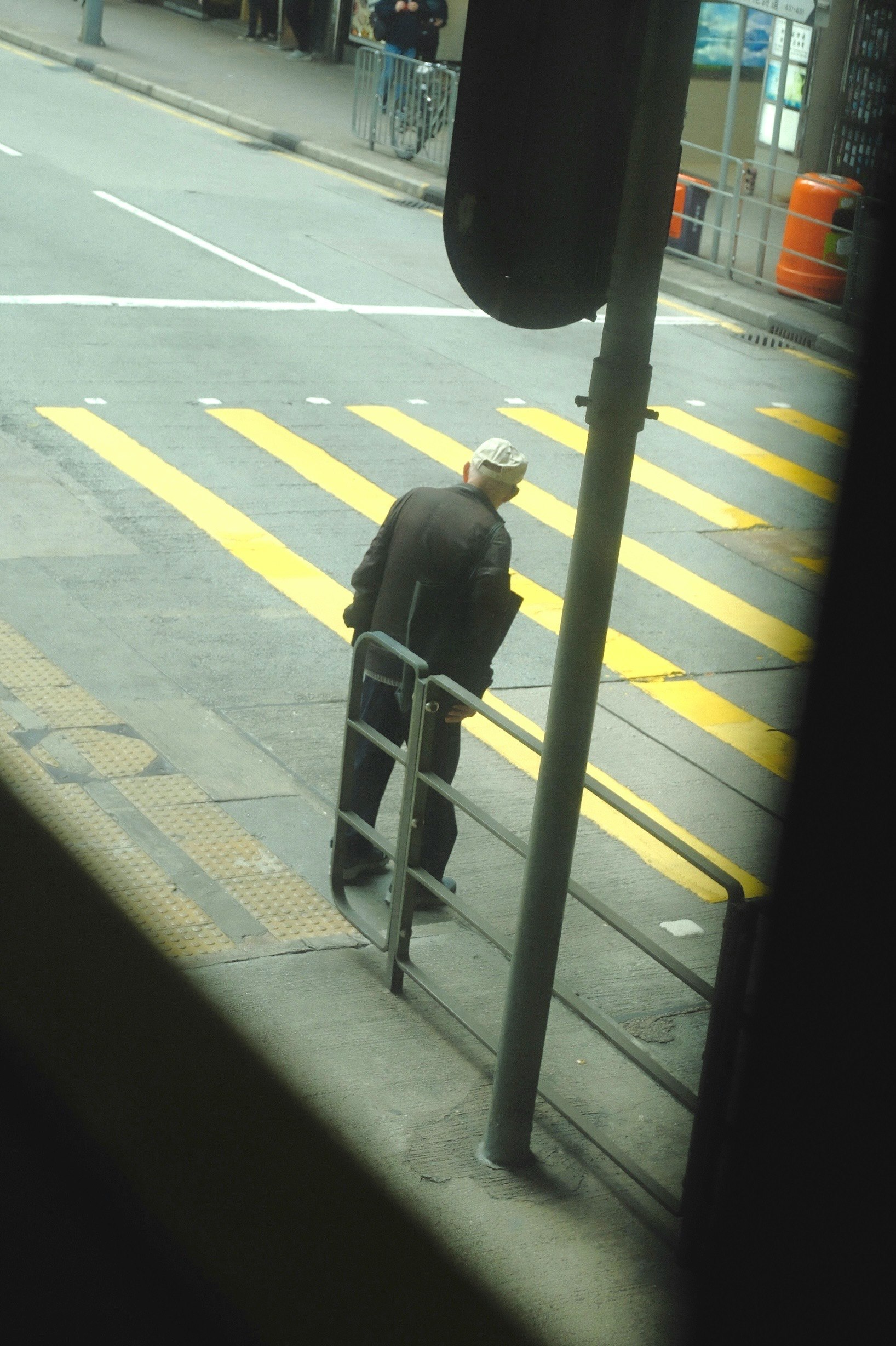 横断歩道のある街角でベンチに座る人