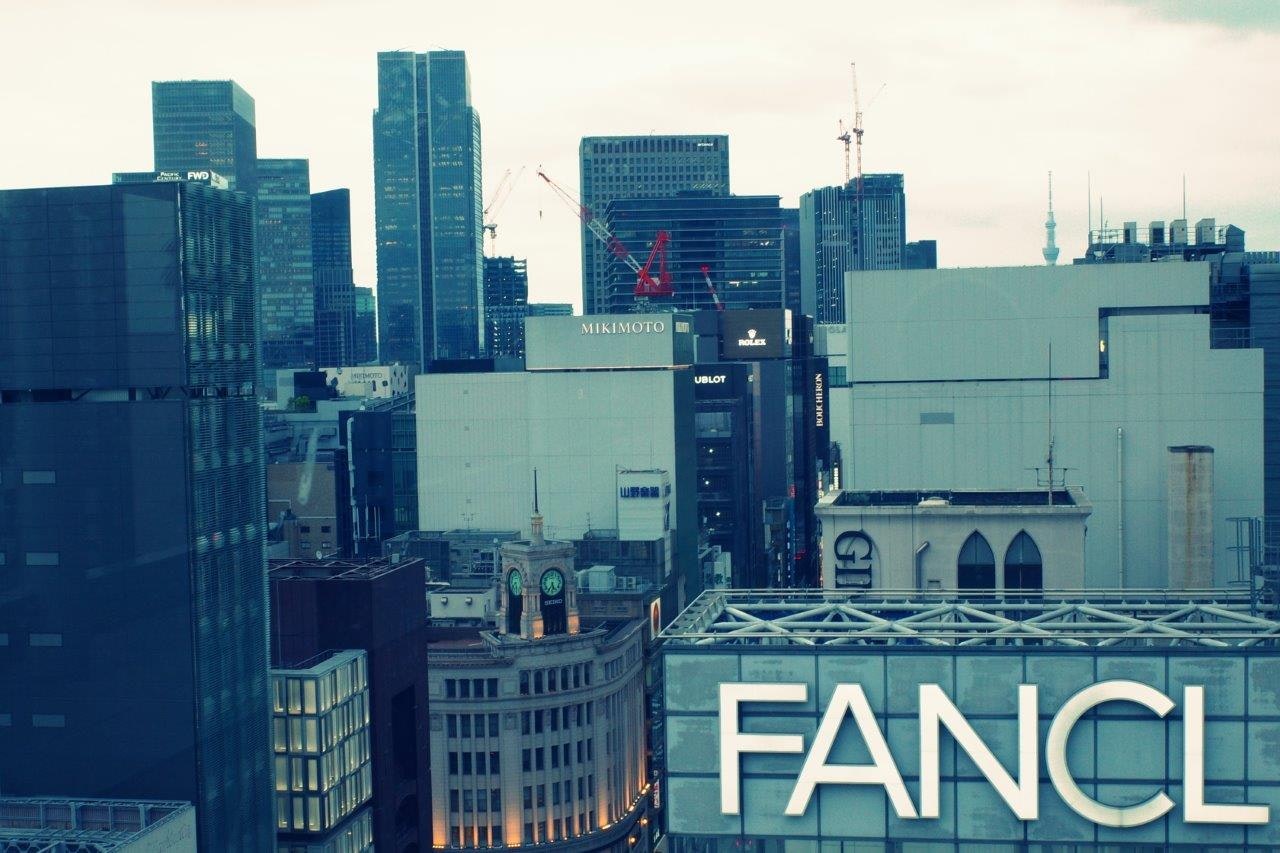 都心のビル群と「FANCL」看板のある屋上景観