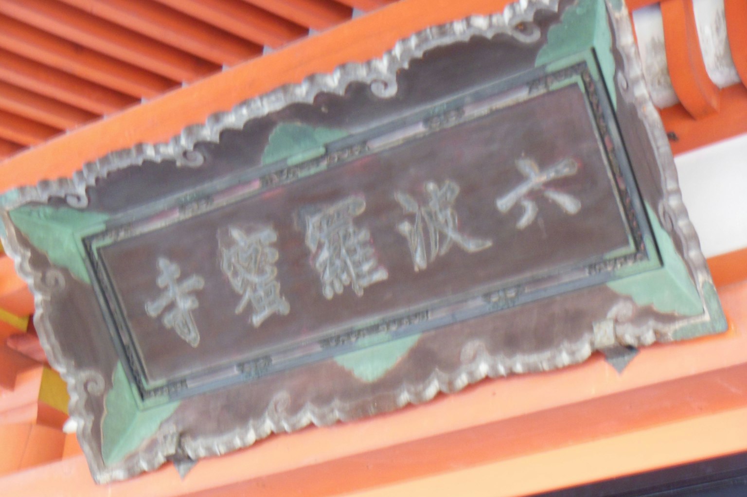 Metal plaque with carved characters on an orange background