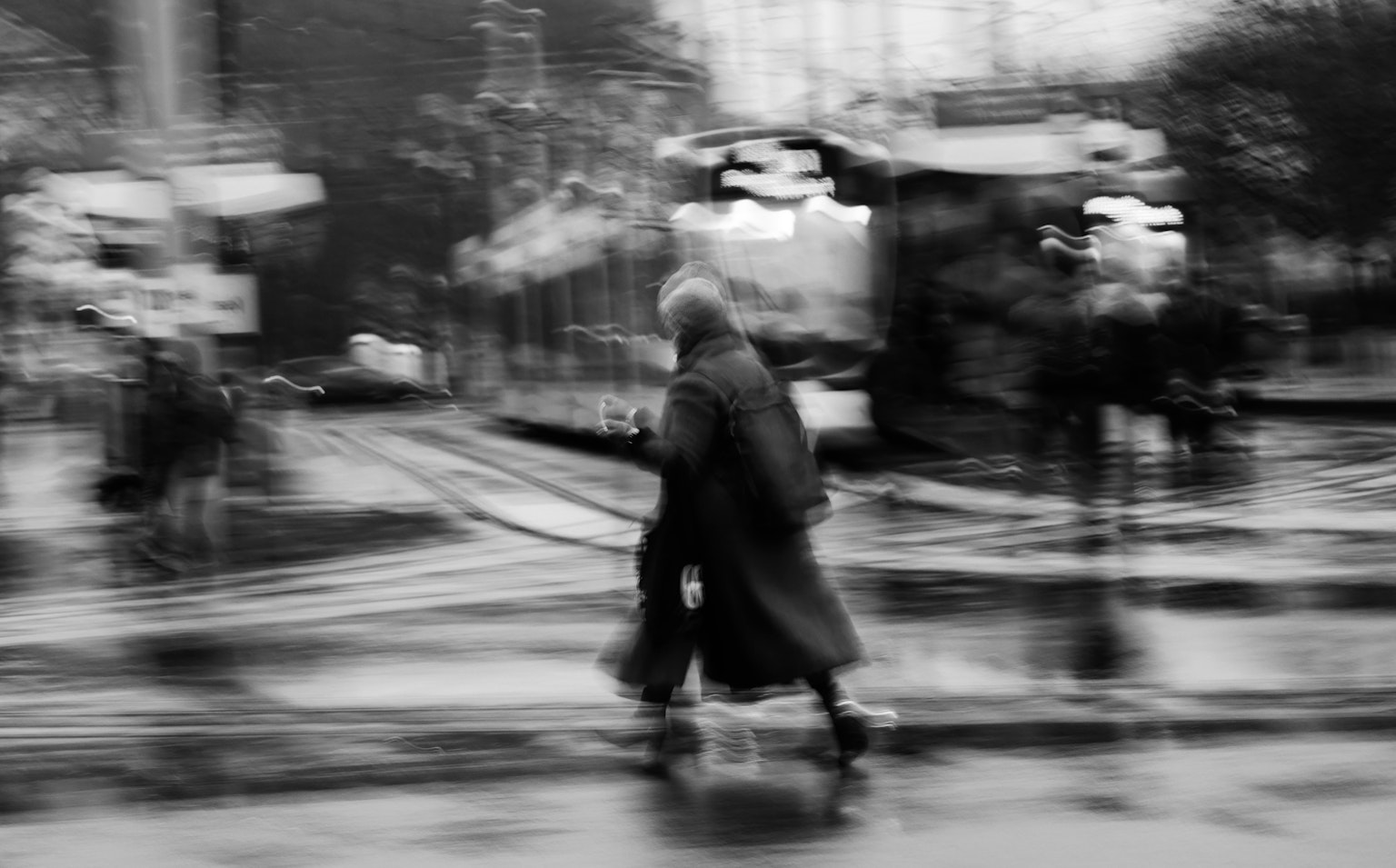 Photo en noir et blanc d'une personne marchant sous la pluie