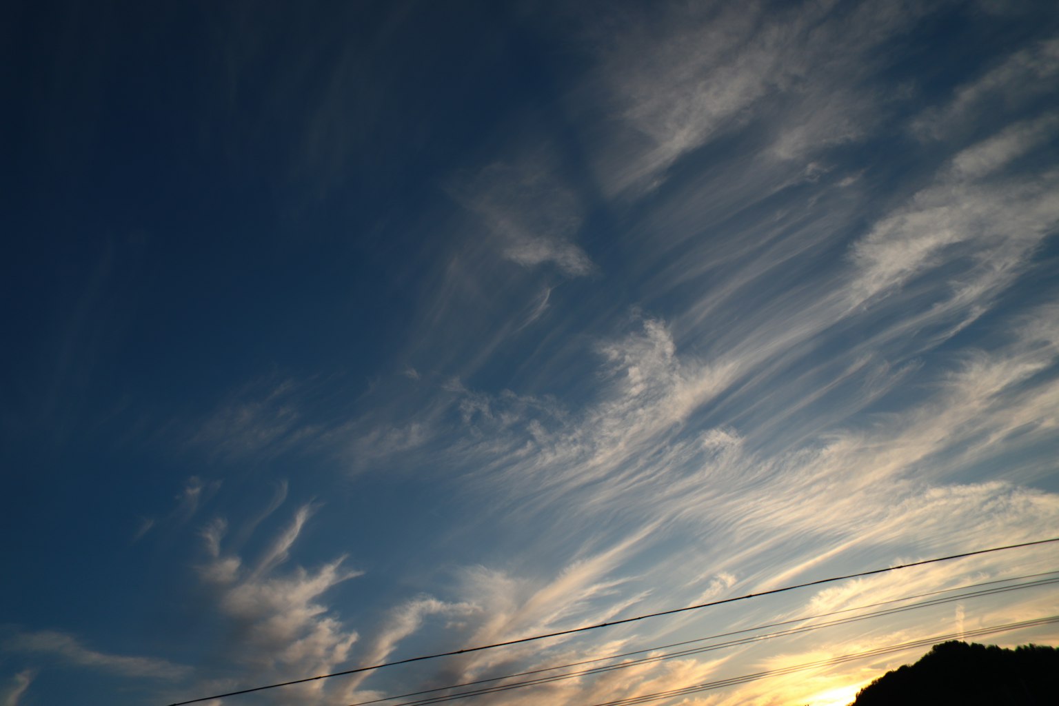 Cielo azul con nubes delgadas y silueta de atardecer