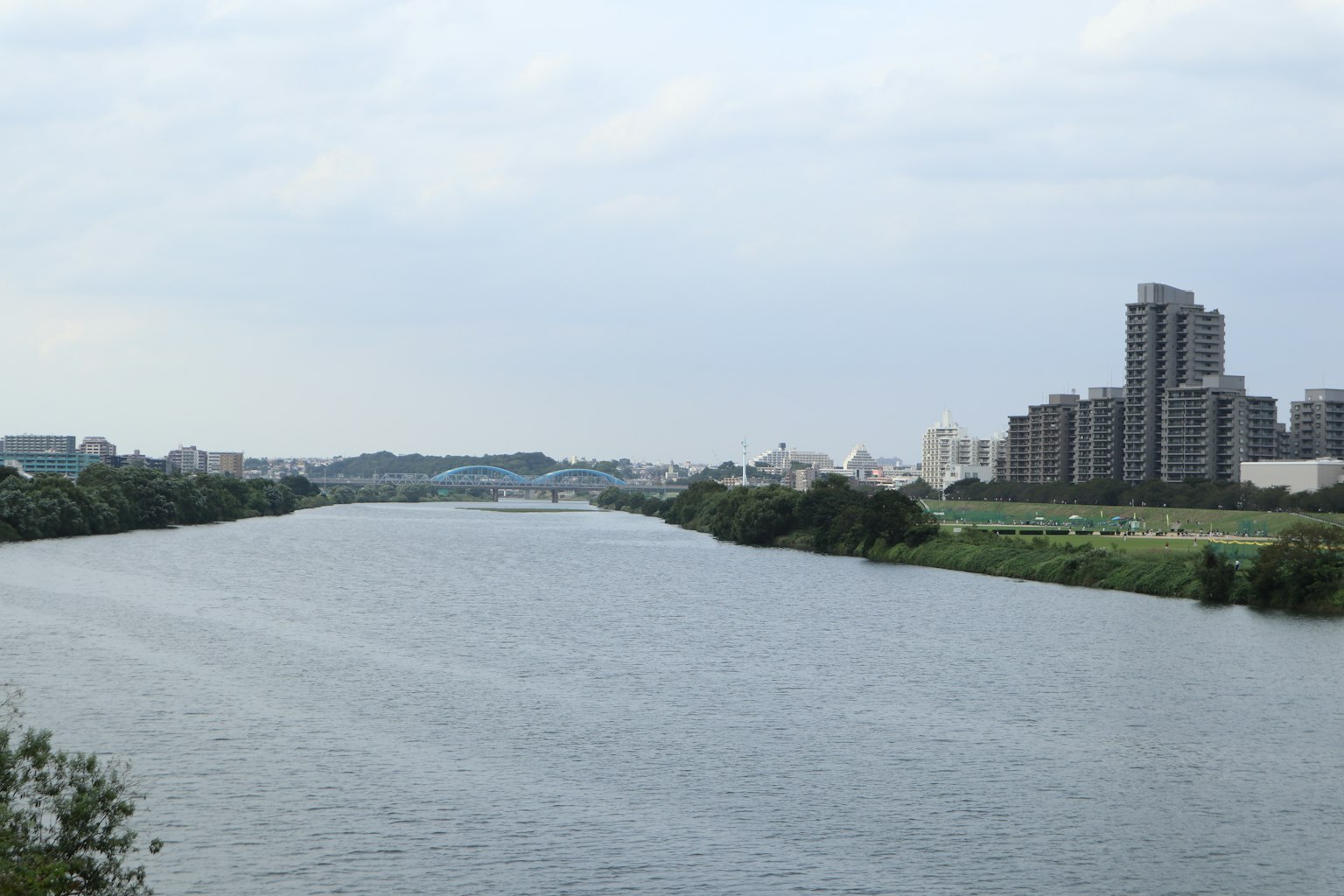 Sungai tenang dengan gedung pencakar langit di sepanjang tepi