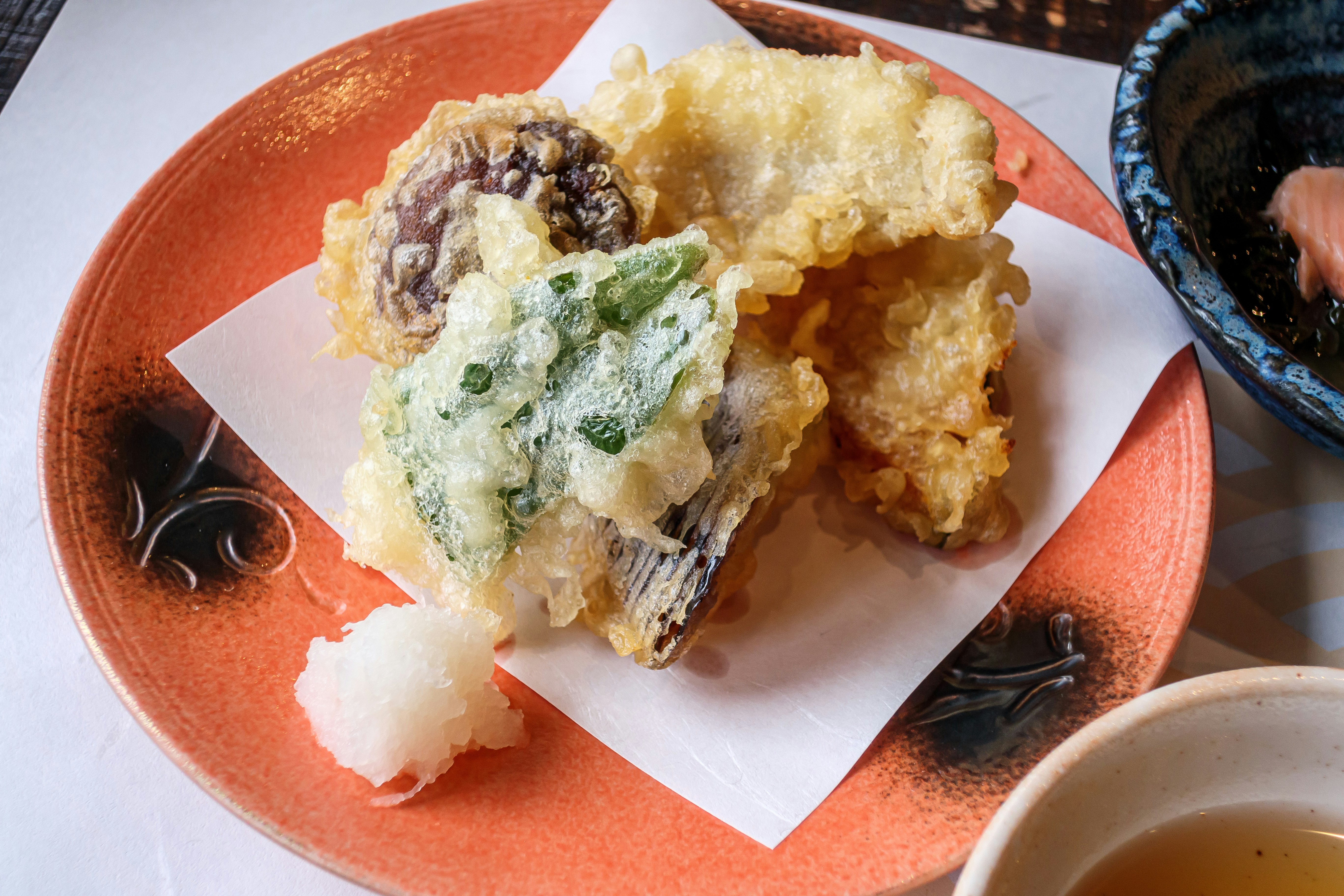 天ぷらの盛り合わせが載った赤い皿