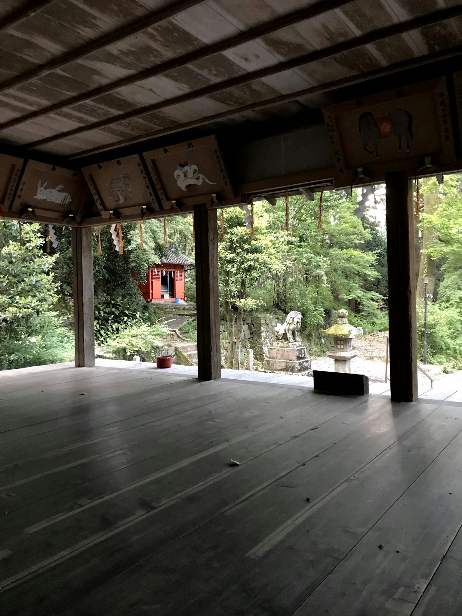 從木結構看向寧靜的花園和紅色建築