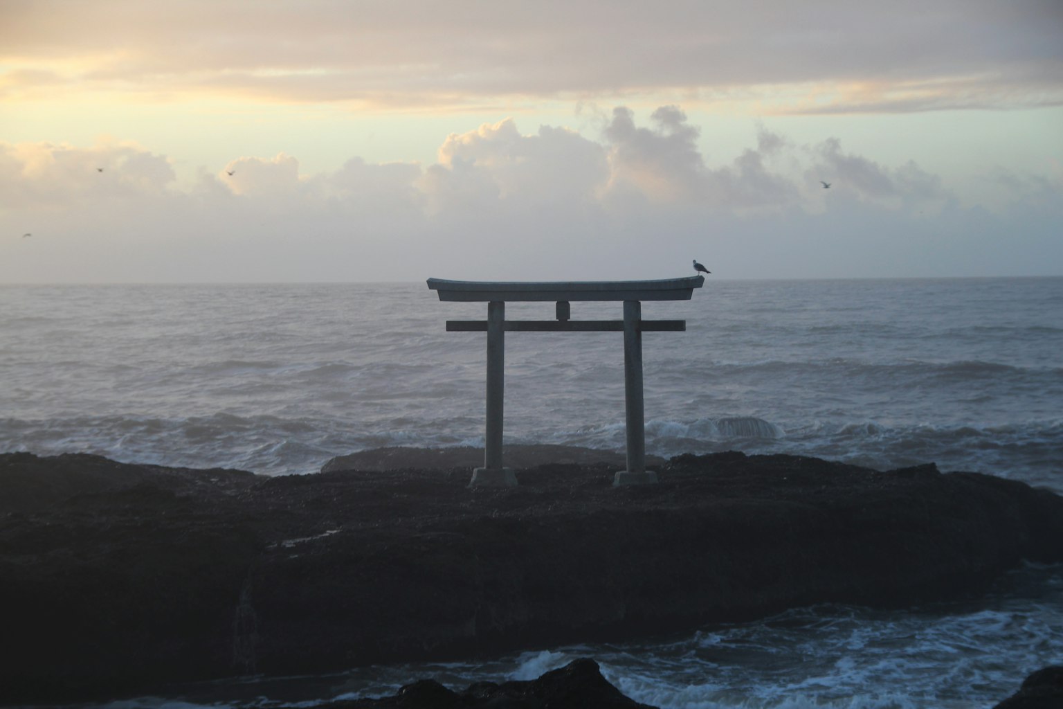 Torii gate at sea with a sunset backdrop