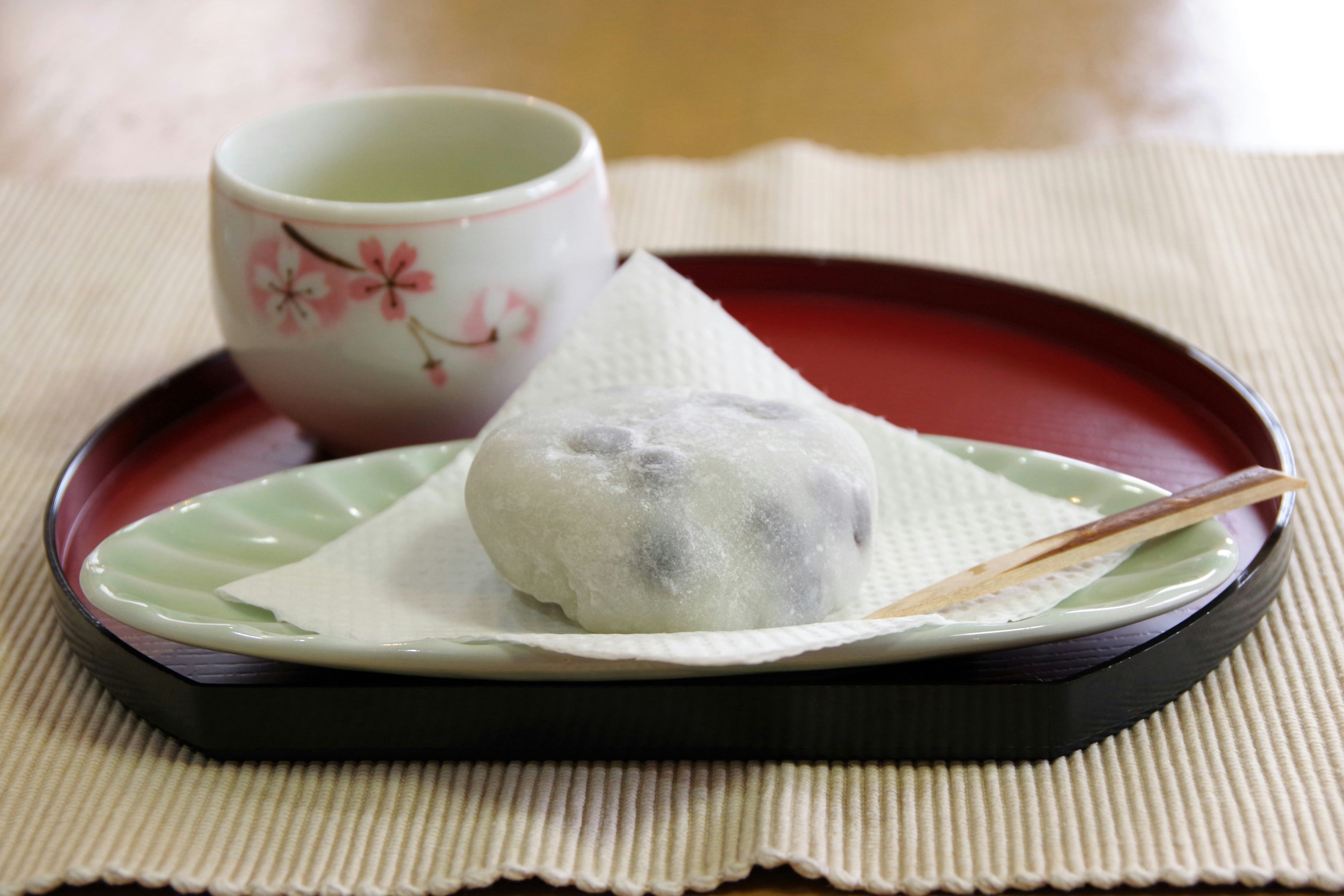 湯気の立つ和菓子と抹茶のある茶卓