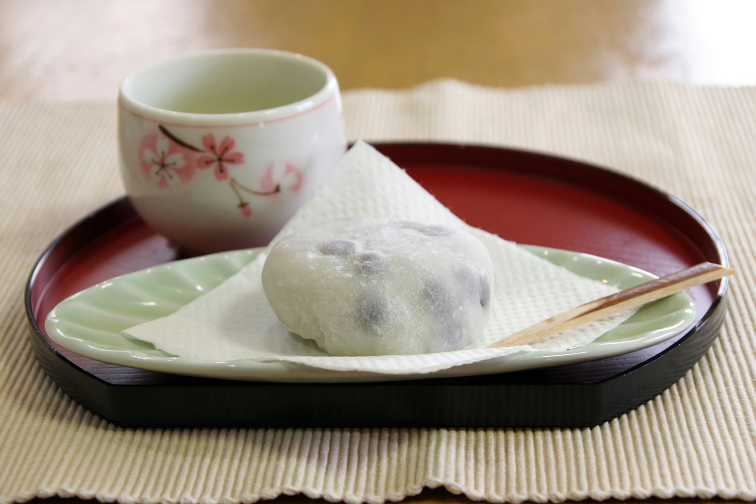 Makanan penutup Jepang tradisional disajikan dengan teh di piring dekoratif