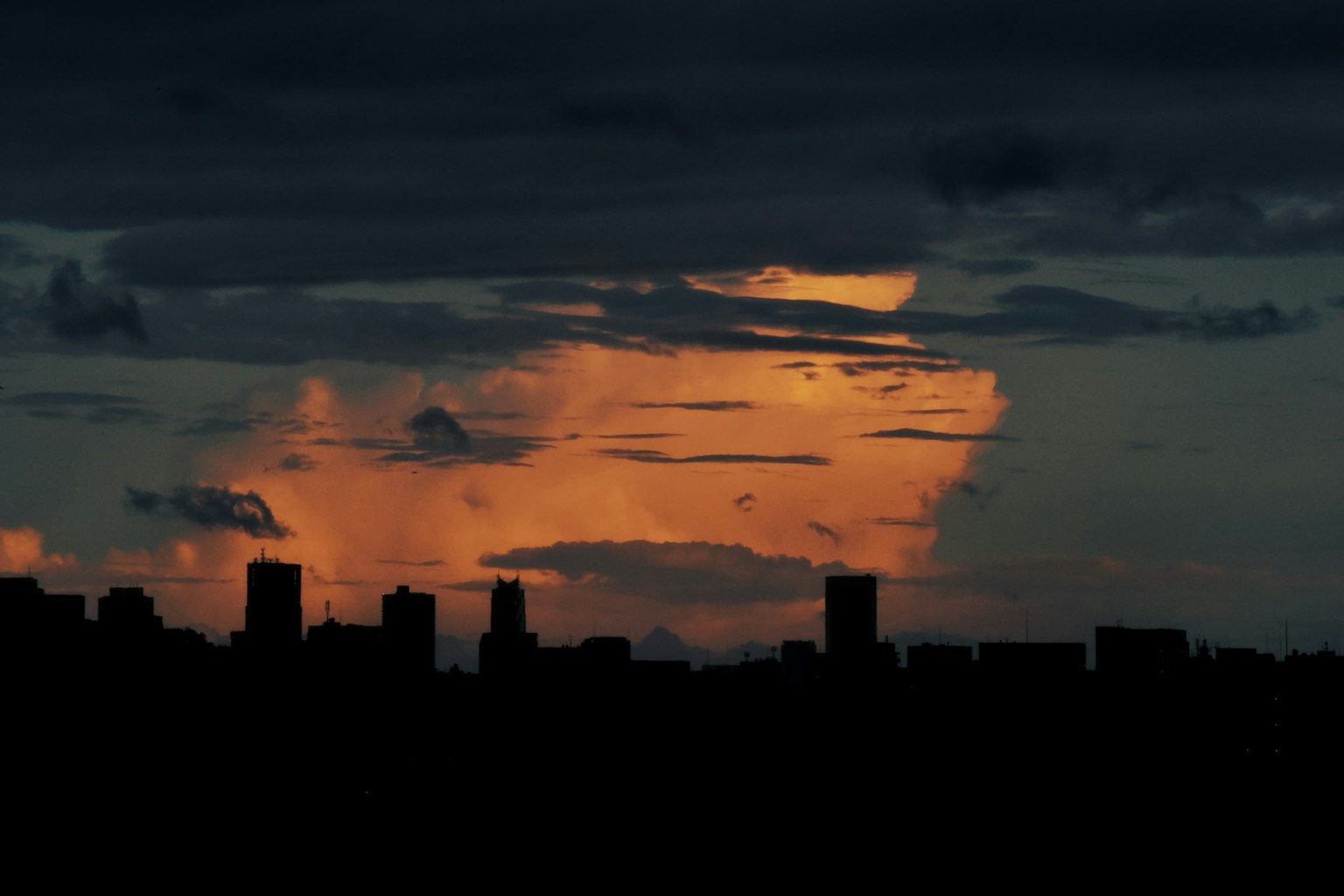City skyline silhouetted against a vibrant sunset sky