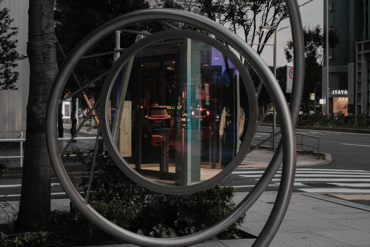 透過圓形金屬框架看到的夜景和商店燈光