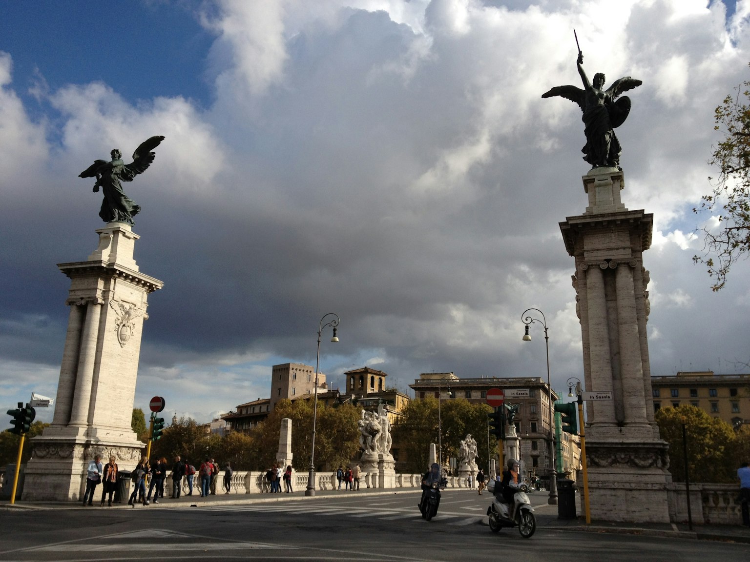 Cảnh một quảng trường ở Rome với tượng thiên thần và bầu trời nhiều mây