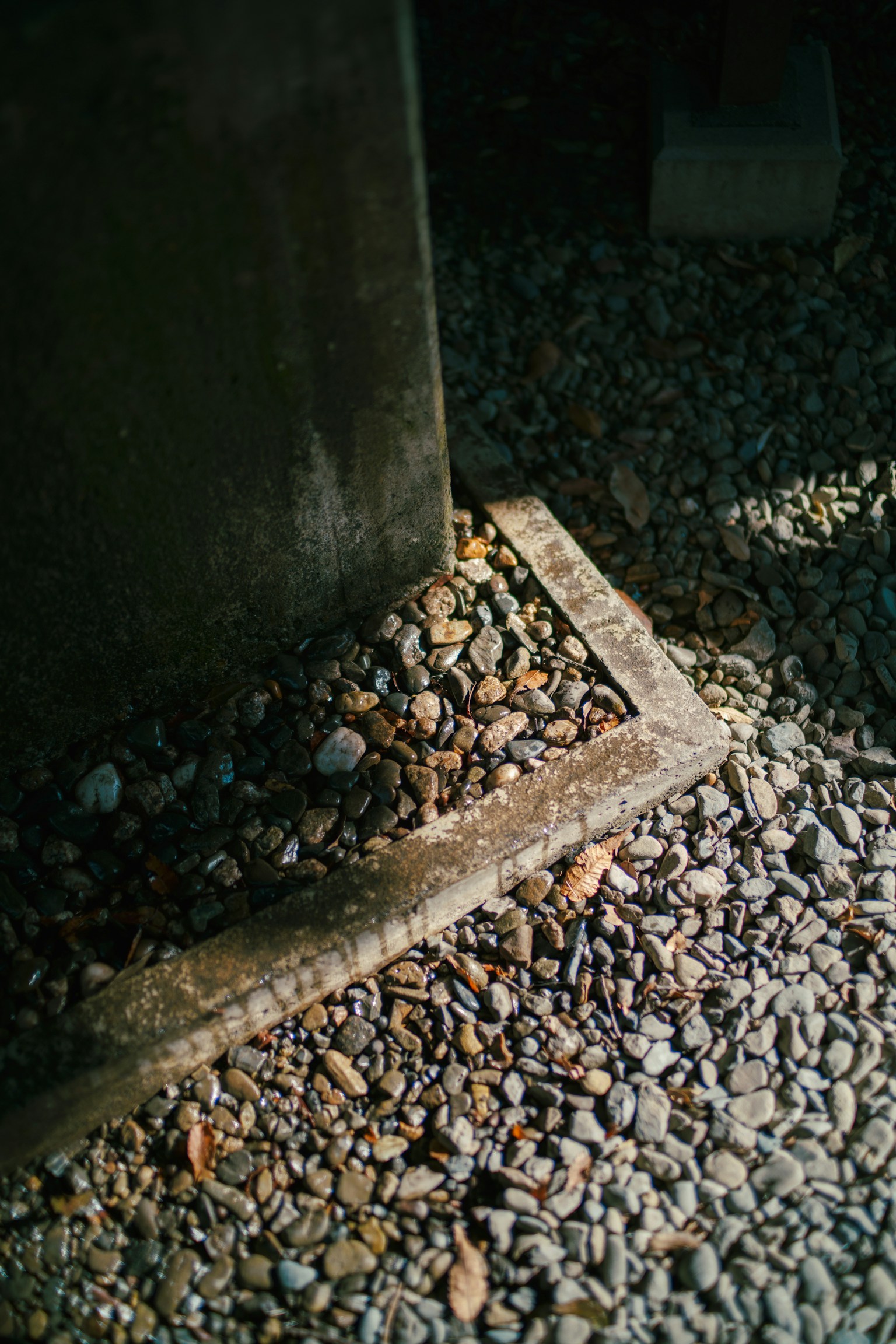 Detail dasar tiang yang berada di atas batu di area gelap