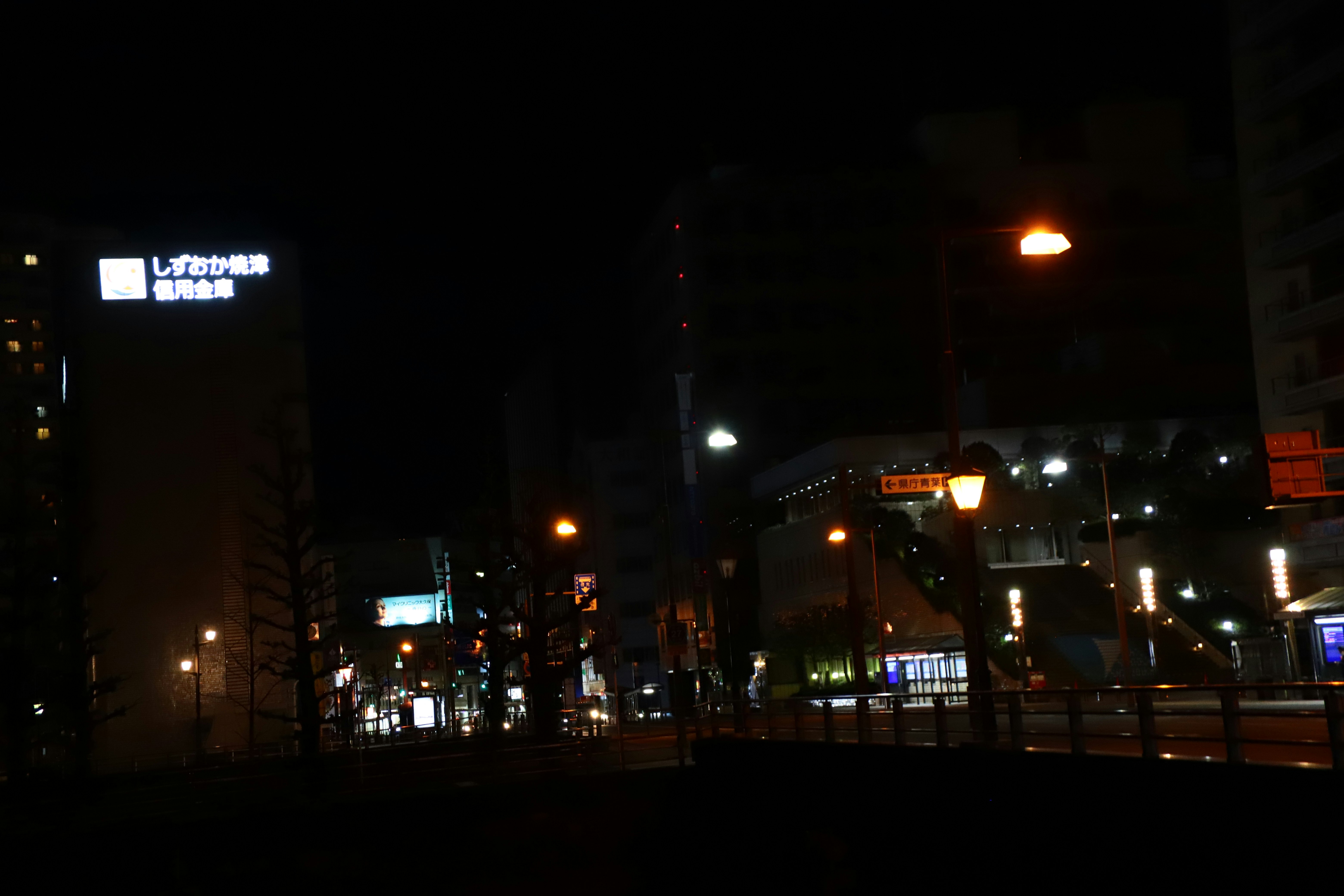 nächtliche Stadtstraßenszene mit einer Hochstraße an einer Kreuzung