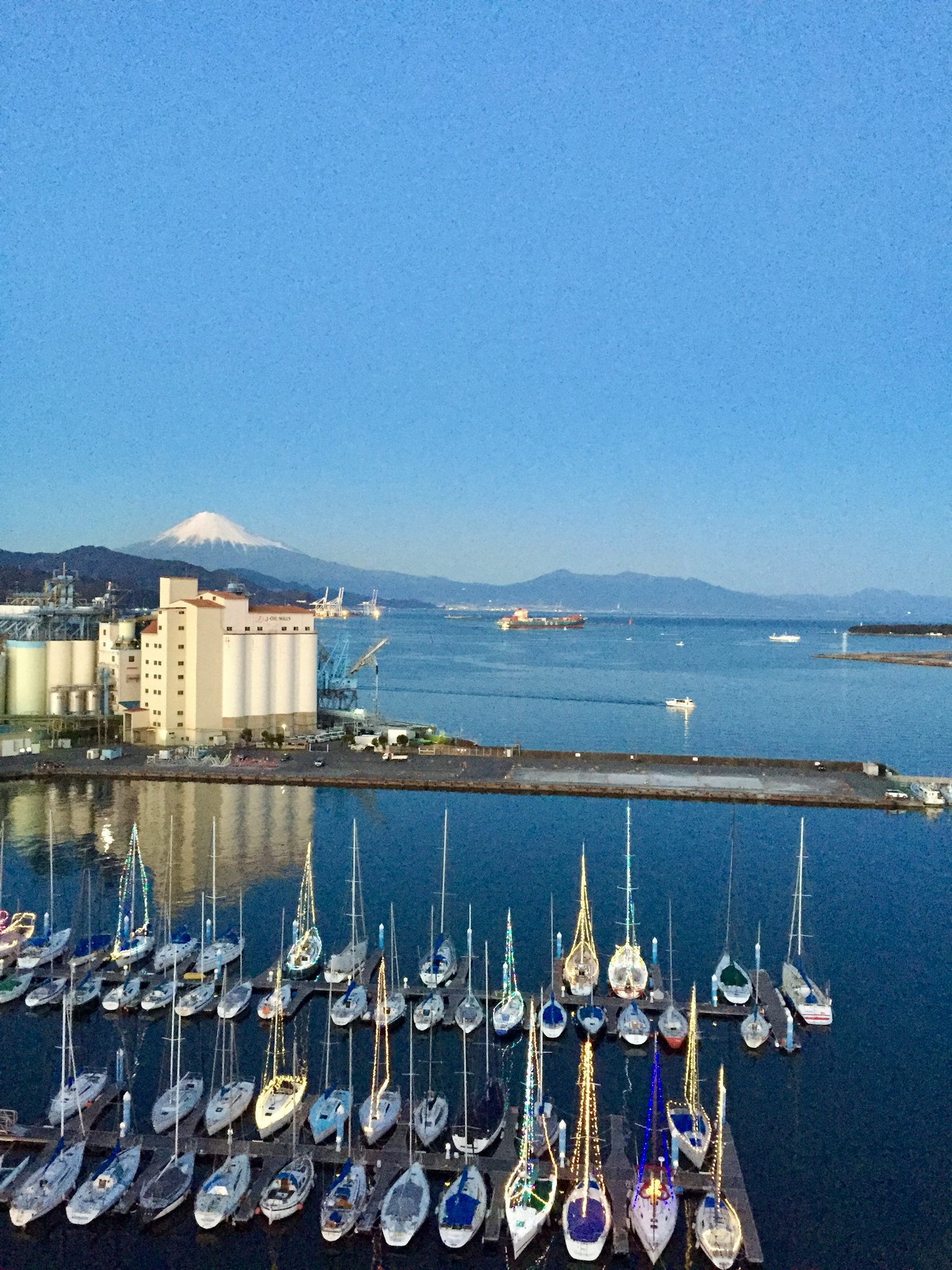 Scenic view of yachts docked in a harbor with mountains in the background