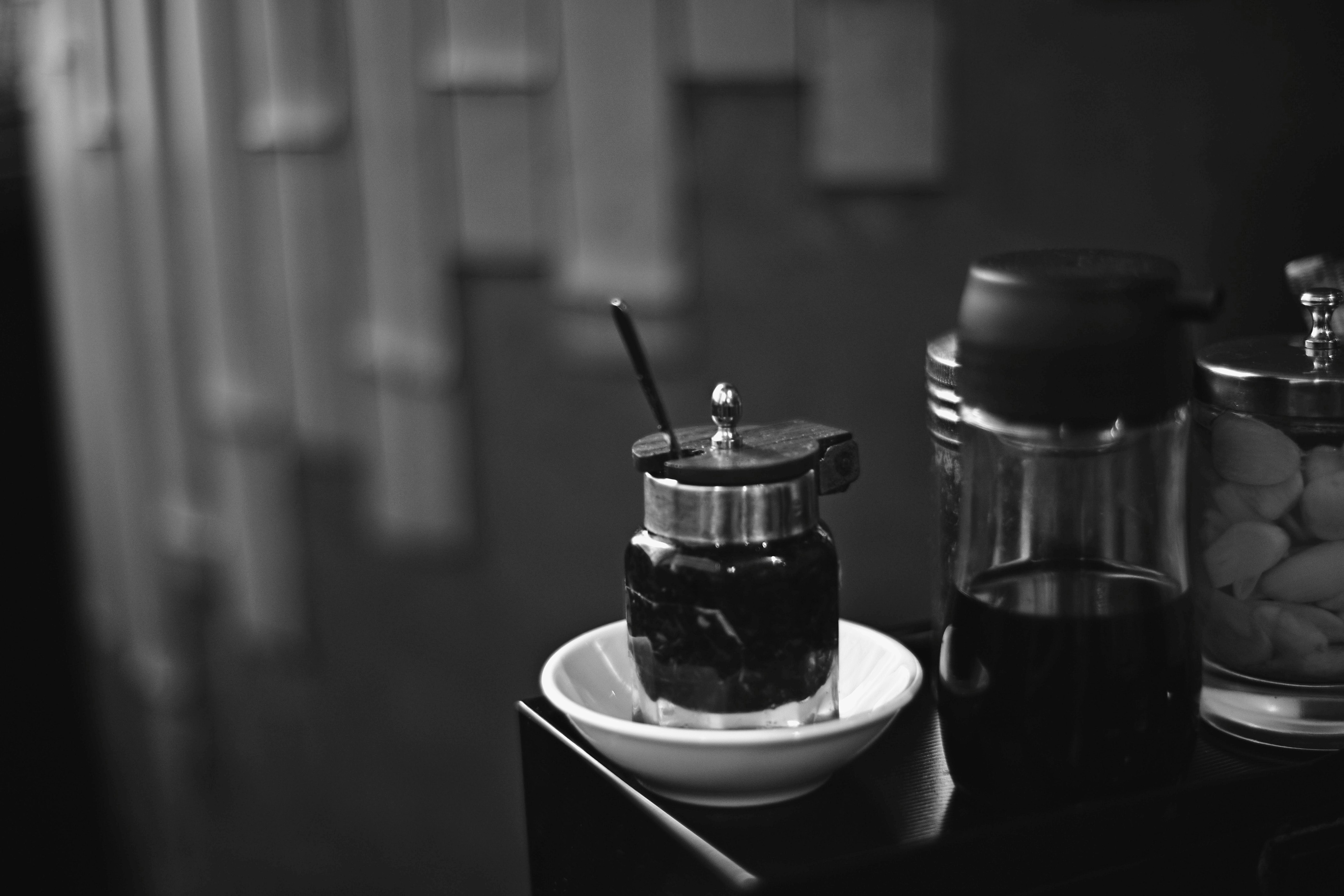 bàn có hũ gia vị màu đen và các bình thủy tinh có vòi