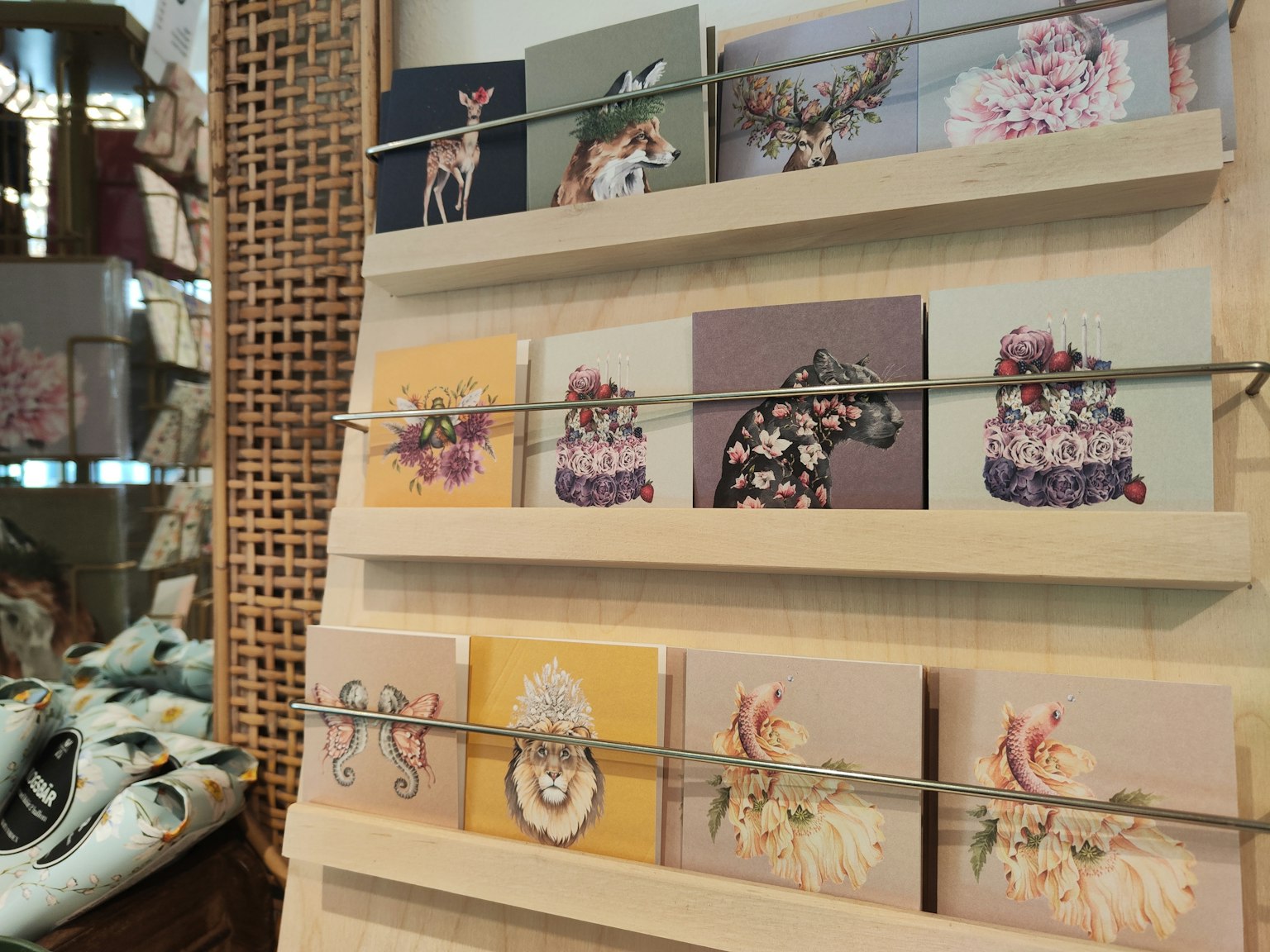 Kunstkarten auf einem Holzständer mit floralen Motiven und Tieren ausgestellt