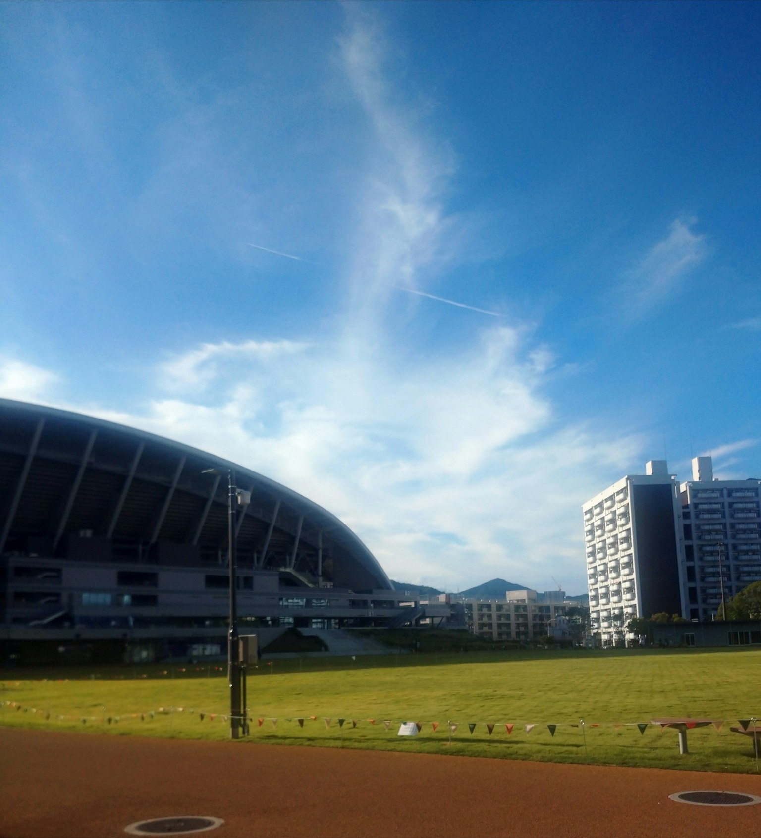 ทัศนียภาพของสนามกีฬาใต้ท้องฟ้าสีฟ้าพร้อมเมฆ