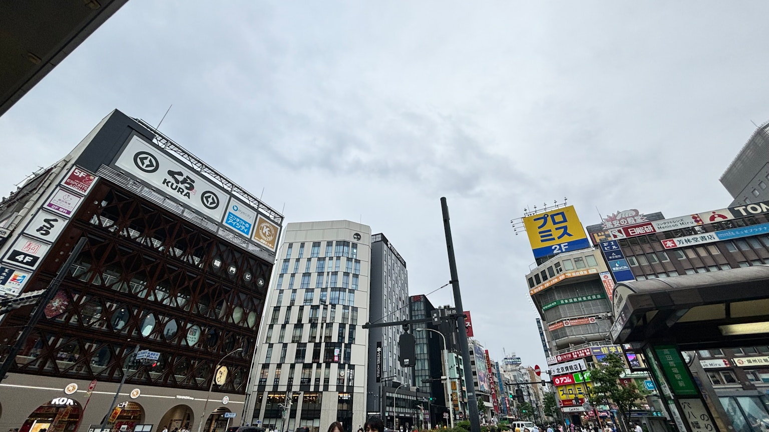 Paisaje urbano bajo un cielo nublado con edificios altos y establecimientos comerciales