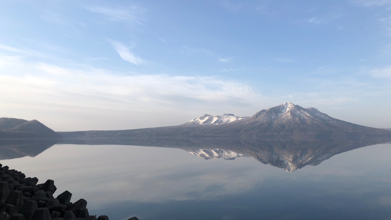 Vista panoramica di una montagna innevata riflessa in un lago sereno