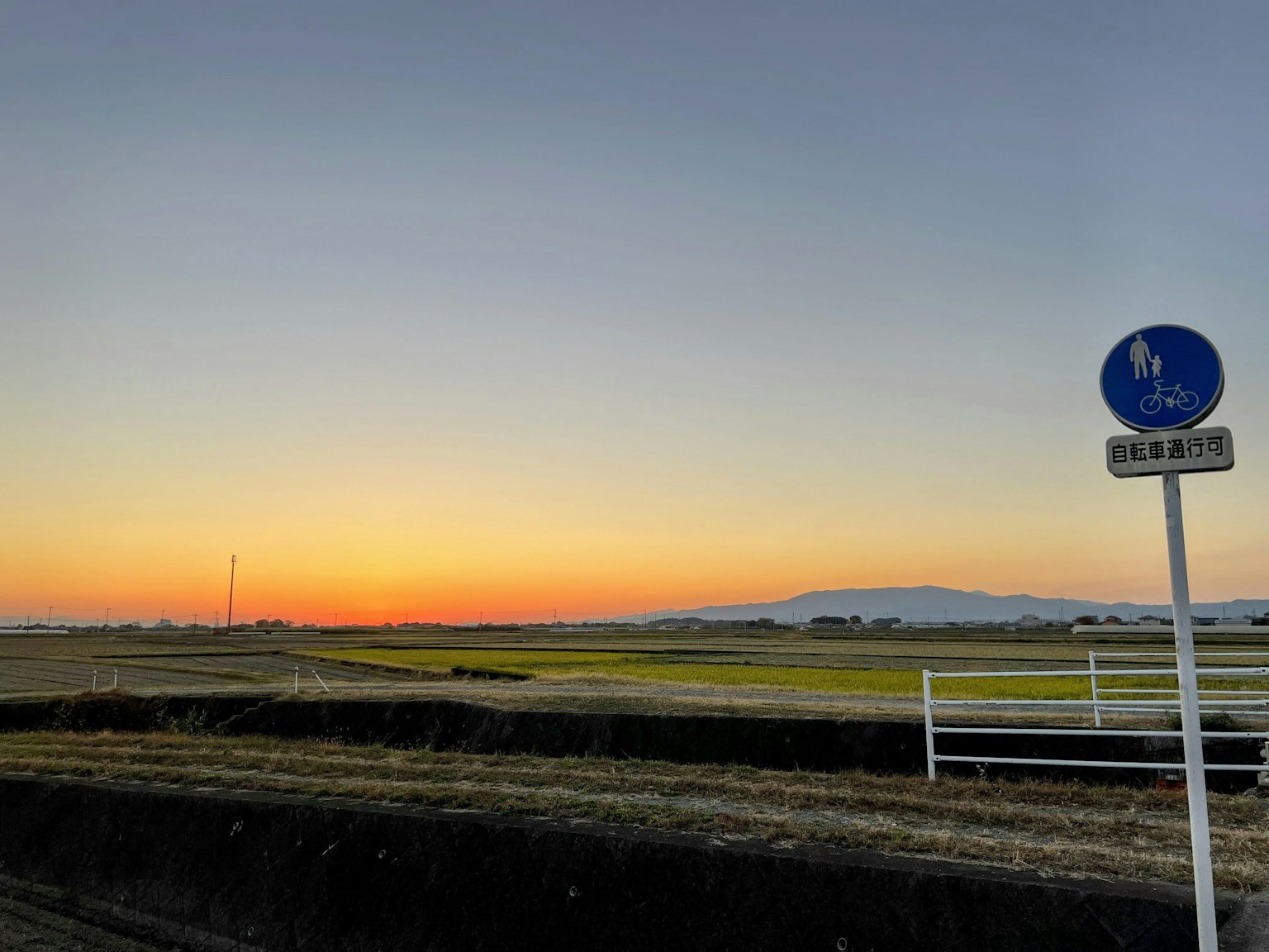 Malerscher Ausblick mit Sonnenuntergang und Fahrradweg-Schild
