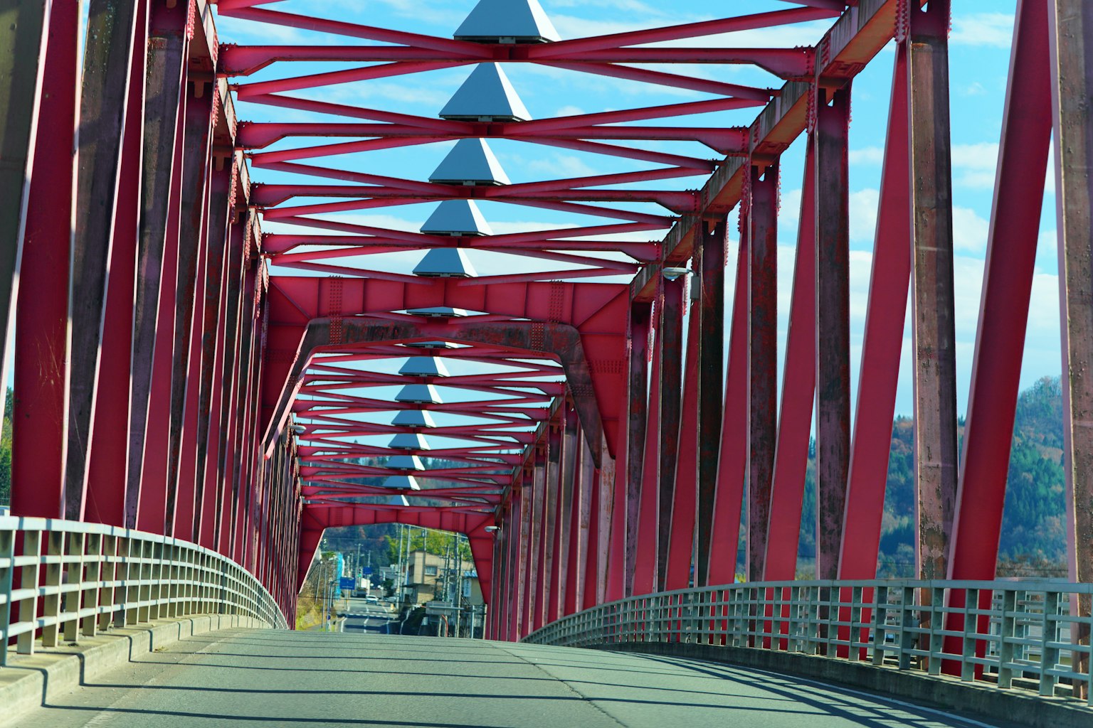 Vista de una carretera debajo de un puente de acero rojo