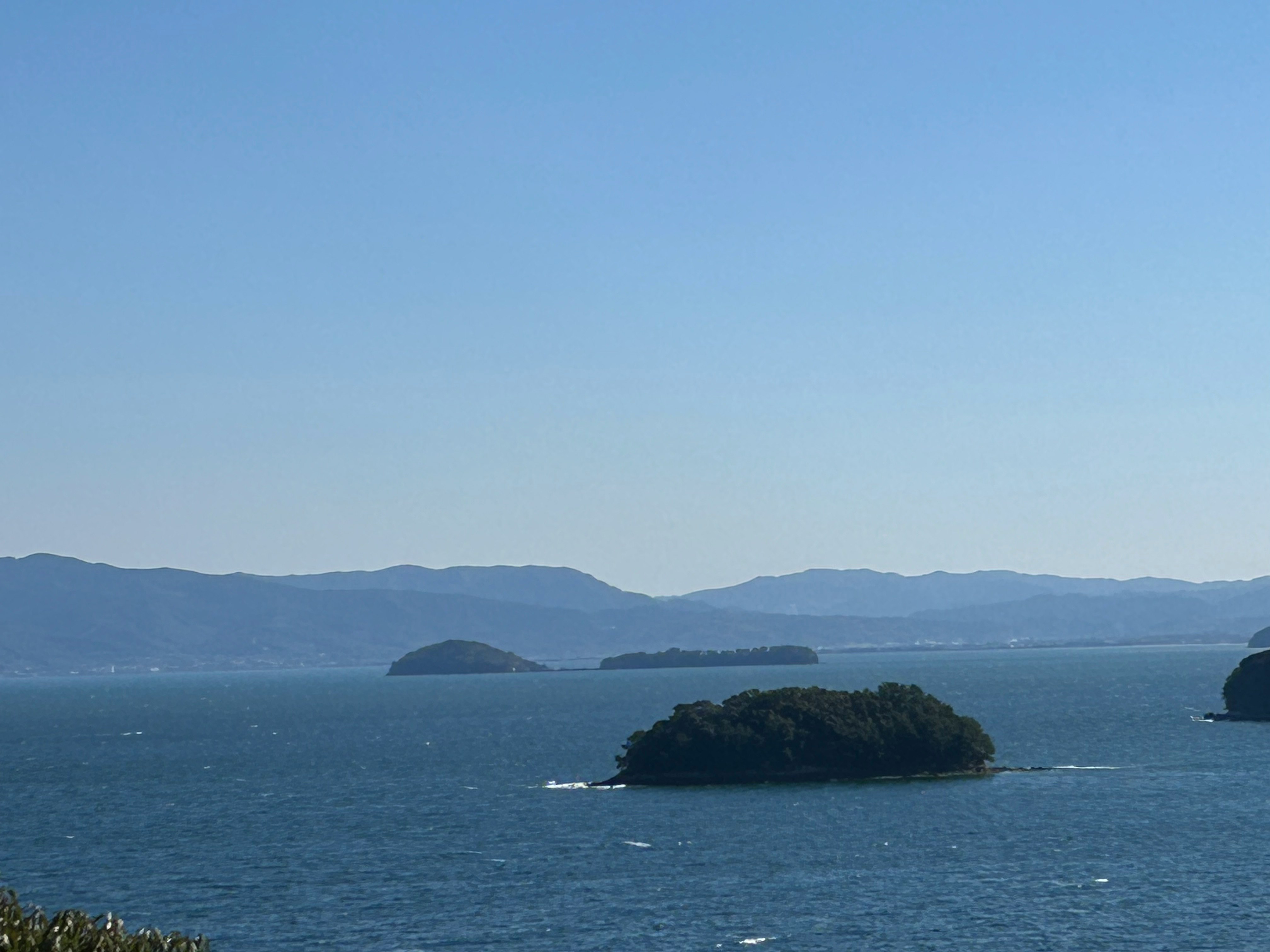 pequeña isla en el mar con montañas a lo lejos