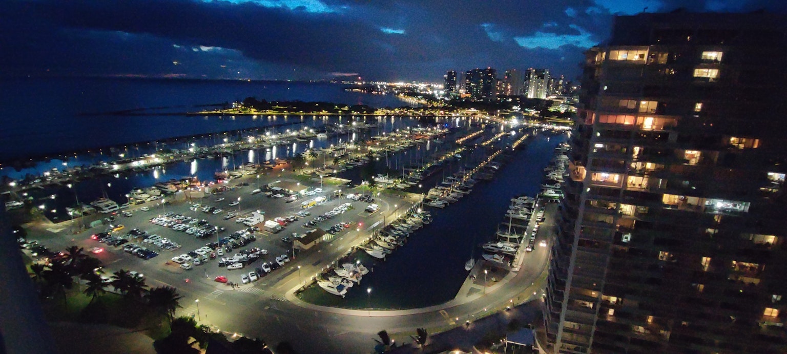 Night view of a harbor with skyscrapers and illuminated boats