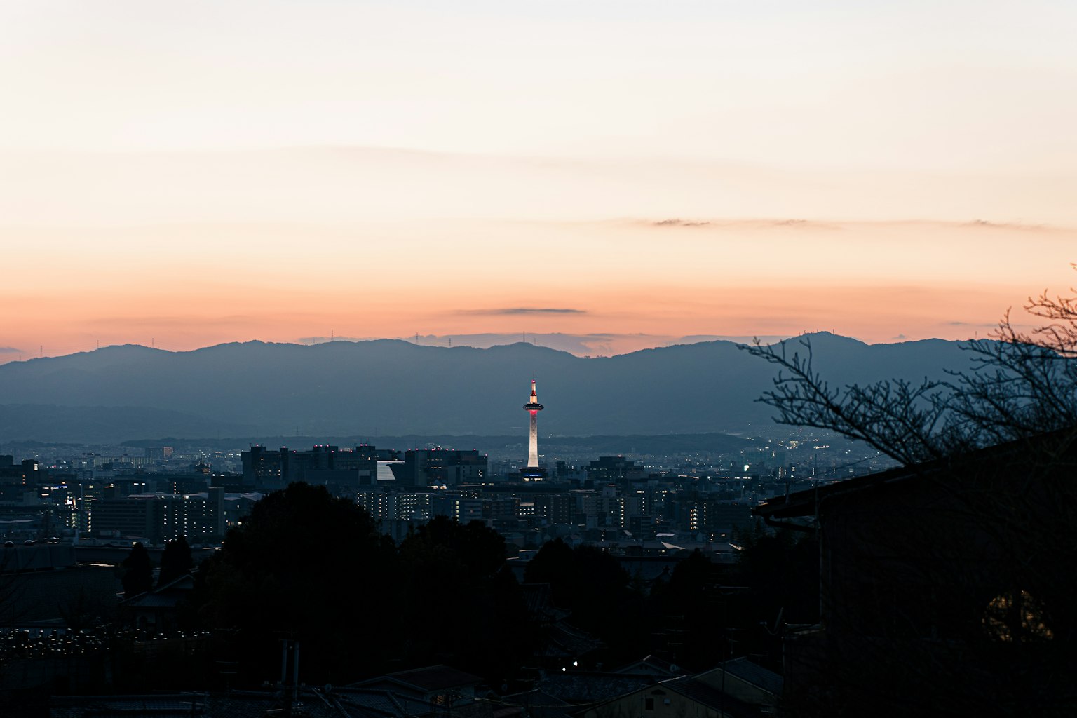 Skyline della città con una torre contro un cielo al tramonto