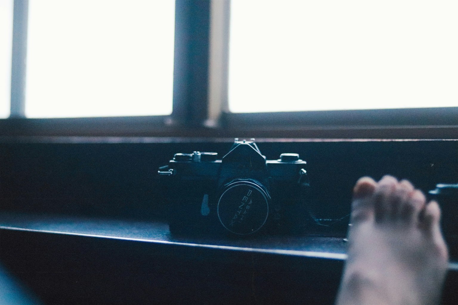 Scene with a camera near a window and a foot in the foreground