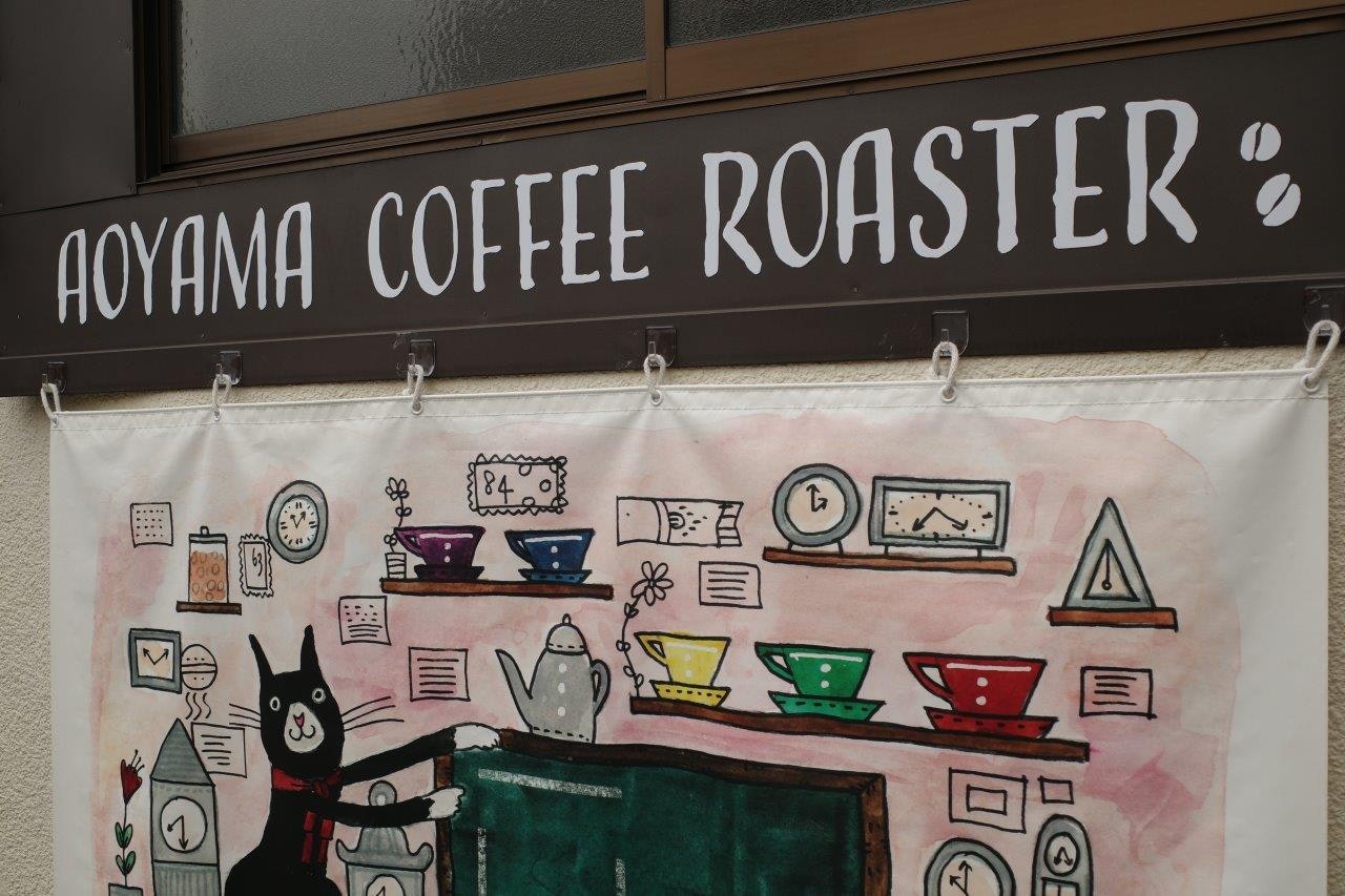 黒板の前に掲げられたコーヒー店のイラスト装飾