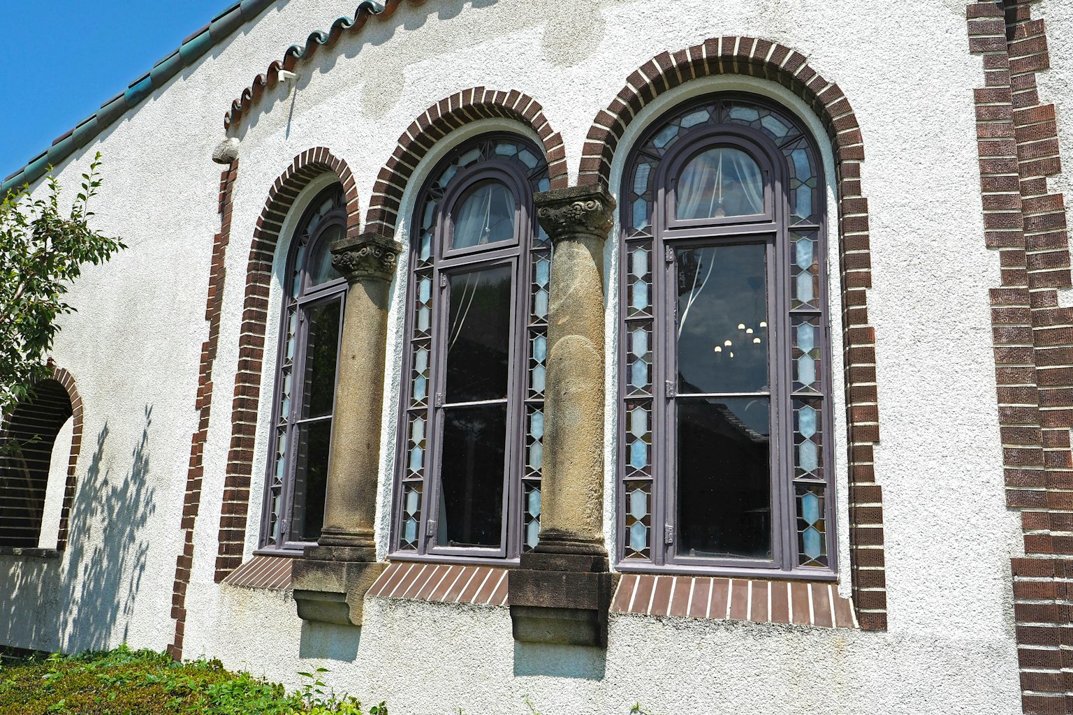 Three arched windows on an old building showcasing unique architectural details