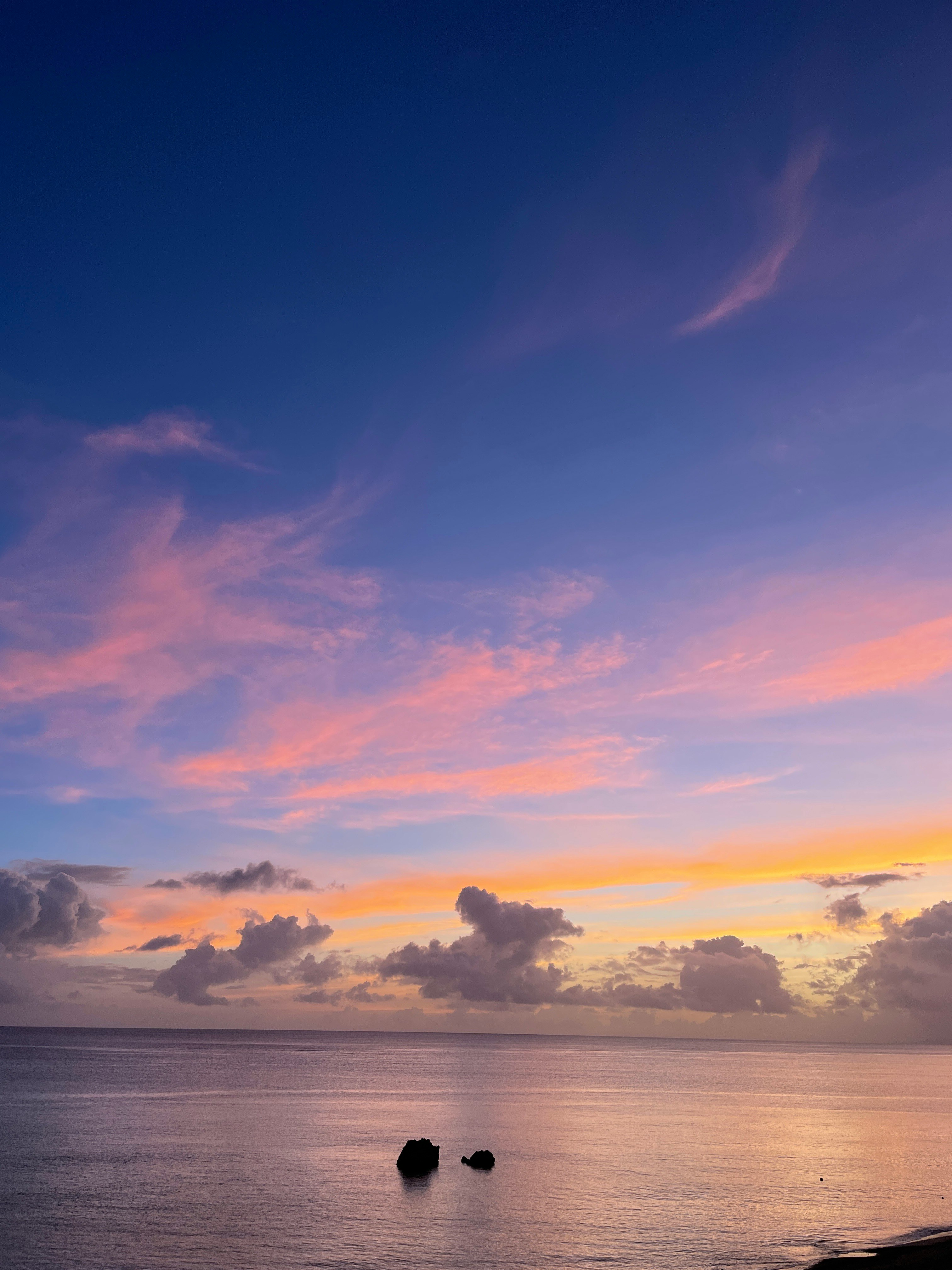 pequeñas rocas en el mar bajo un cielo de atardecer